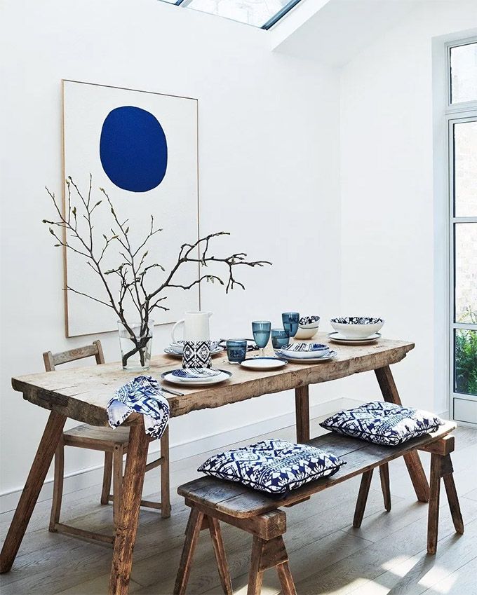 A room in a Japandi style with a wooden table and blue cushions