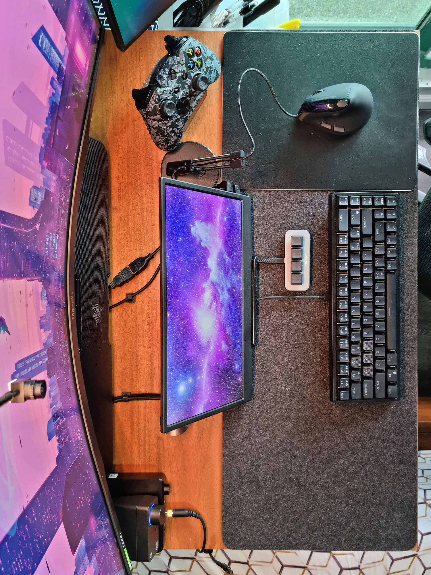 A small home office setup with a curved monitor and 60% mechanical gaming keyboard