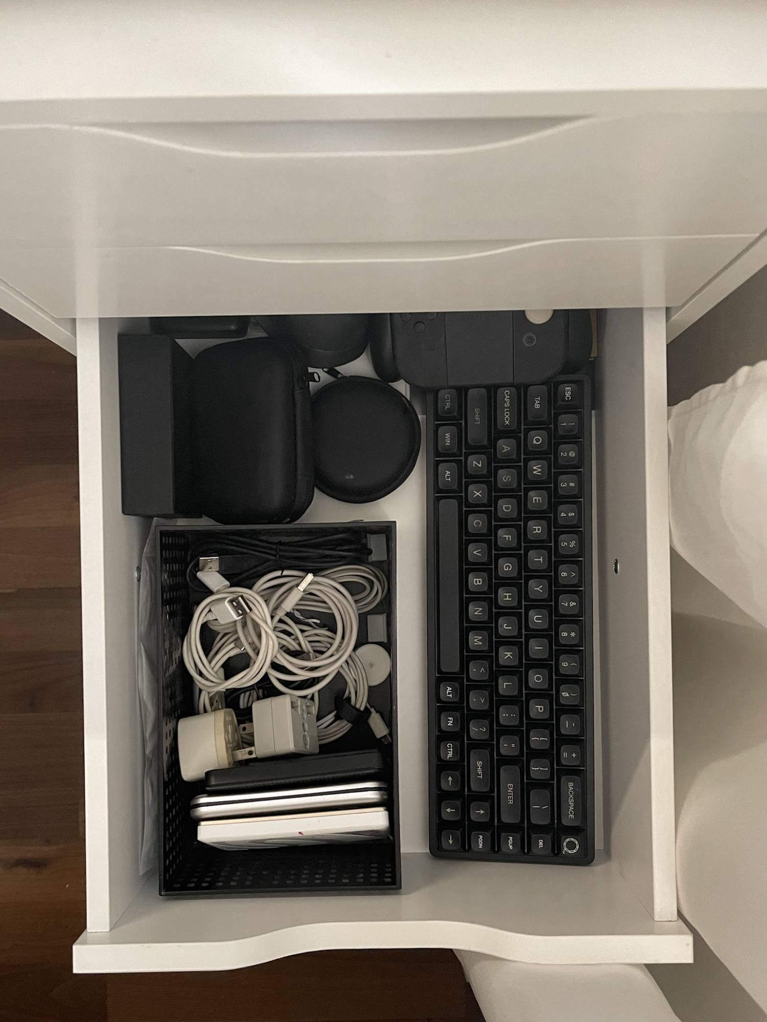 A tech drawer that contains cables, cases, and peripherals