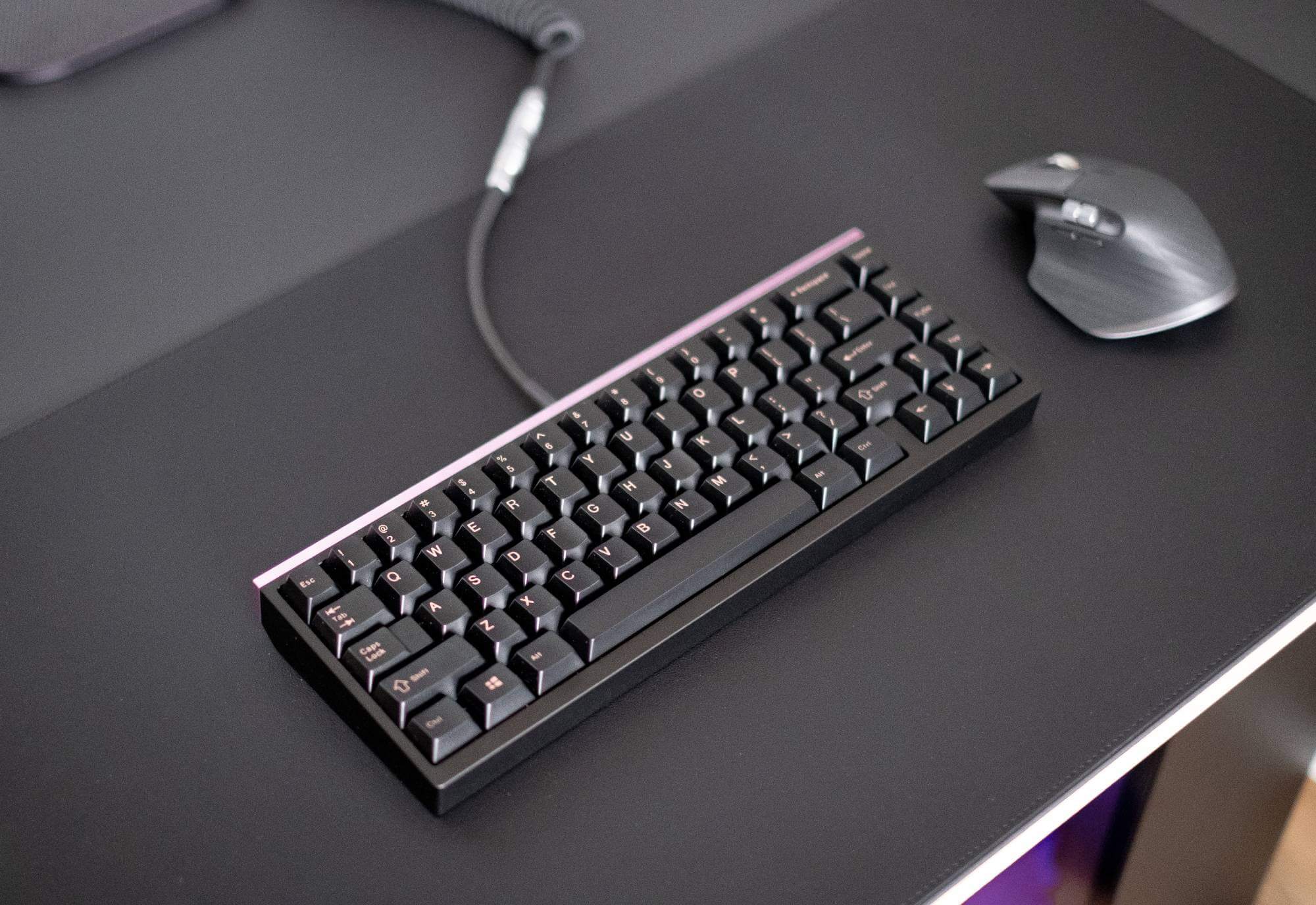 A black Mode65 keyborad with lilac backpiece, paired with EnjoyPBT Pink on Black keycaps, tropical switches (linear, fully lubed/filmed) and connected via a custom-made USB cable from Keebstuff