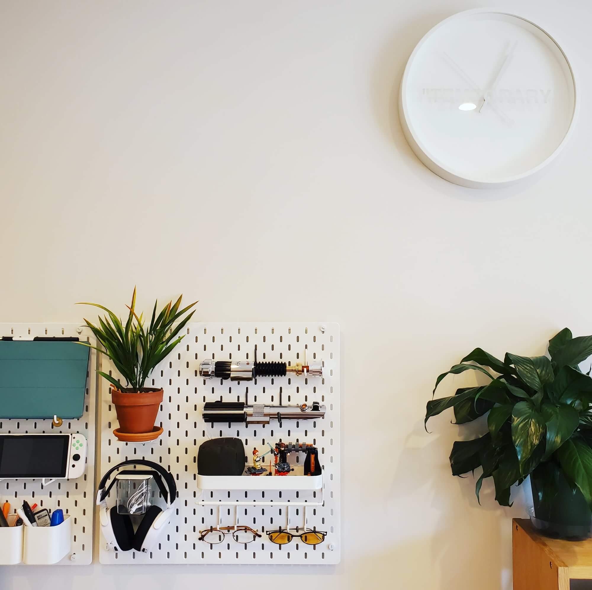 A desk setup pegboard featuring sunglasses, stationary, and other personal items