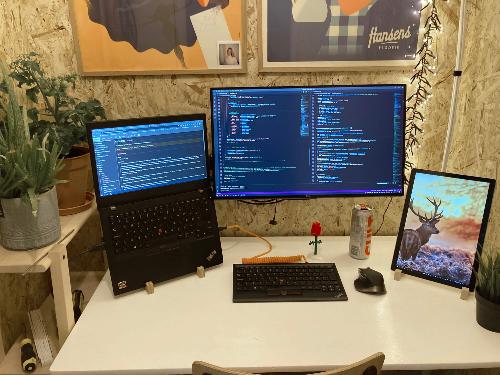 A small space desk setup with a monitor, laptop, tablet and keyboard