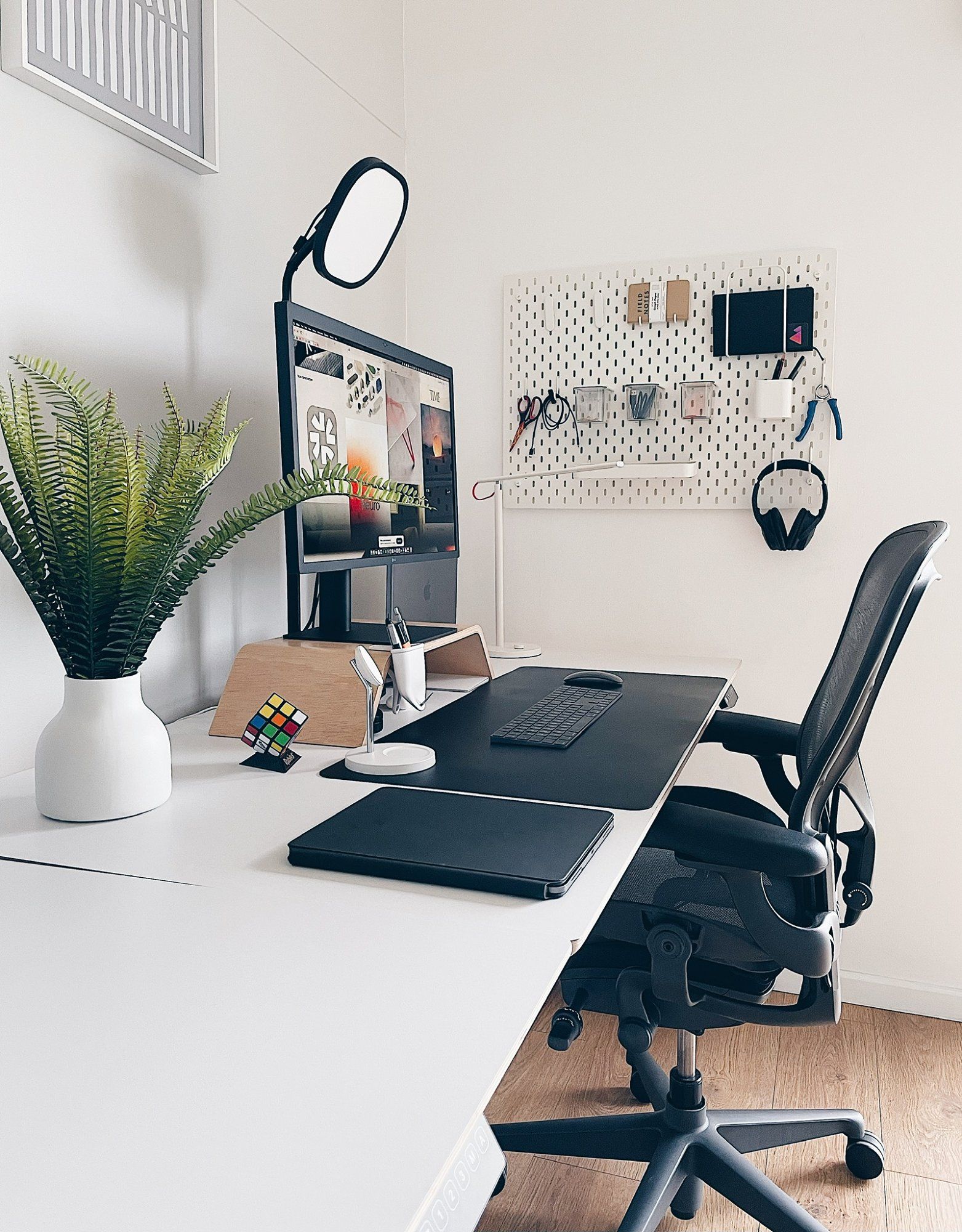 A minimal standing desk setup with a Herman Miller Aeron chair