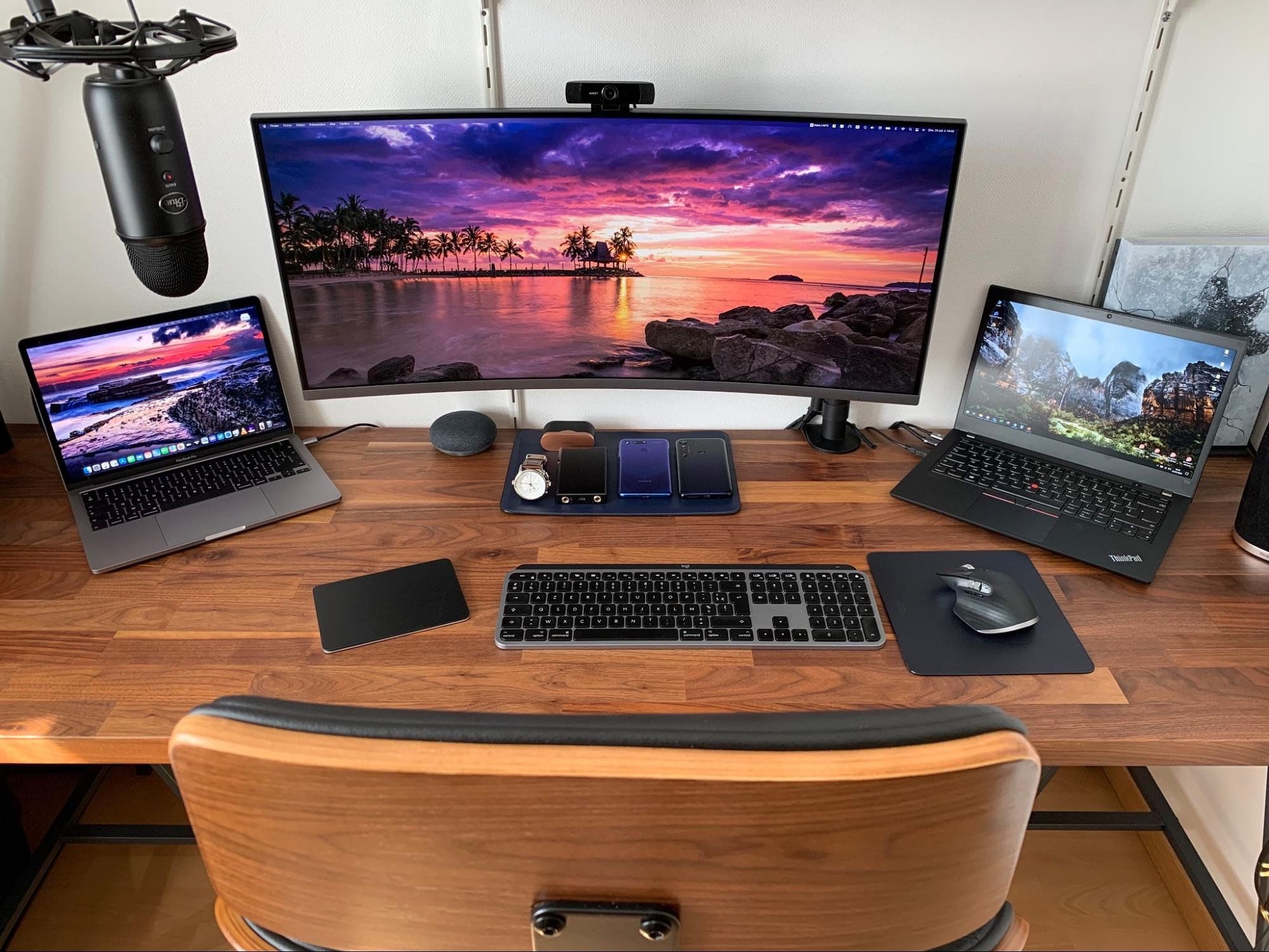 A home workspace with a Samsung ultra-wide screen and two laptops