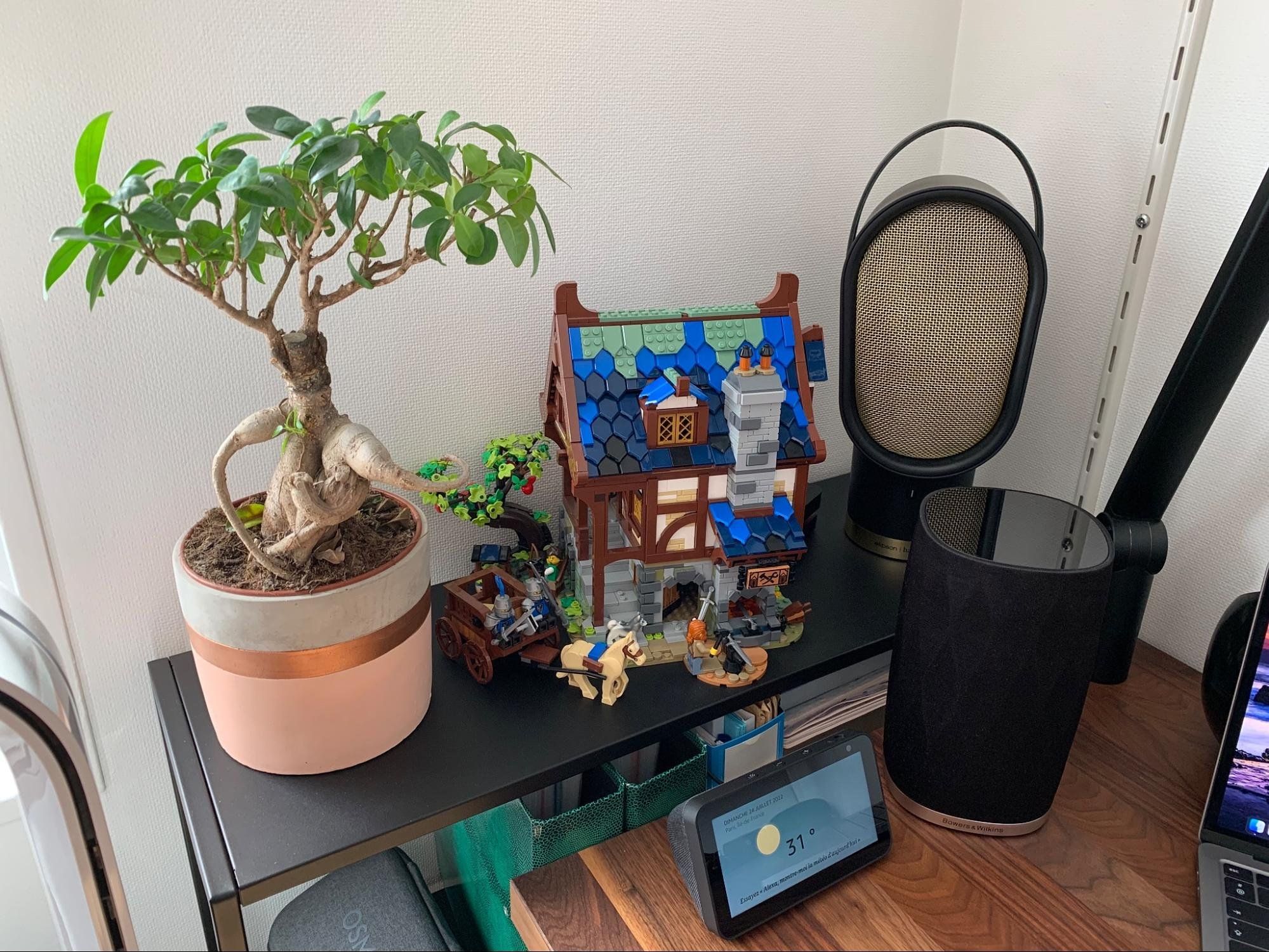 A Bonsai tree and a Lego medieval forge in a home workspace in Paris, France