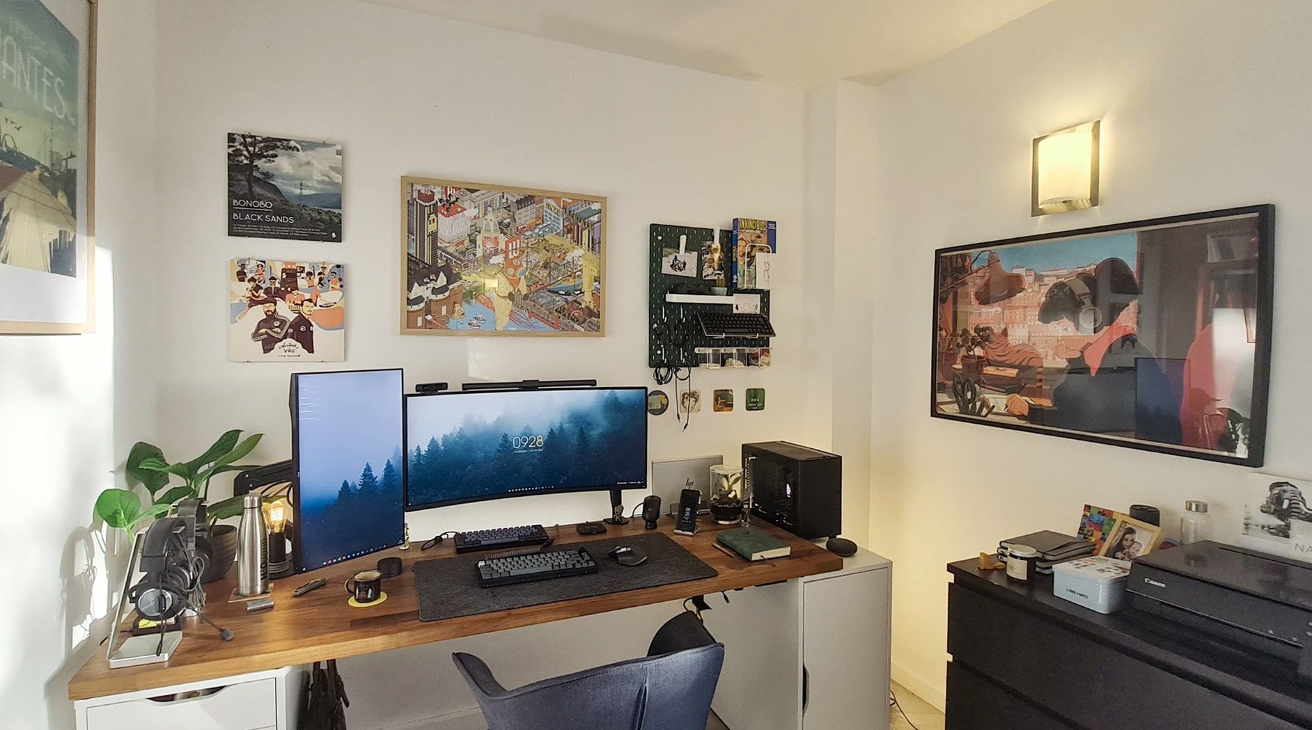 A home office featuring a range of colours (green, wood, black, silver, grey, and yellow) and materials (metal, wood, felt, and glass)