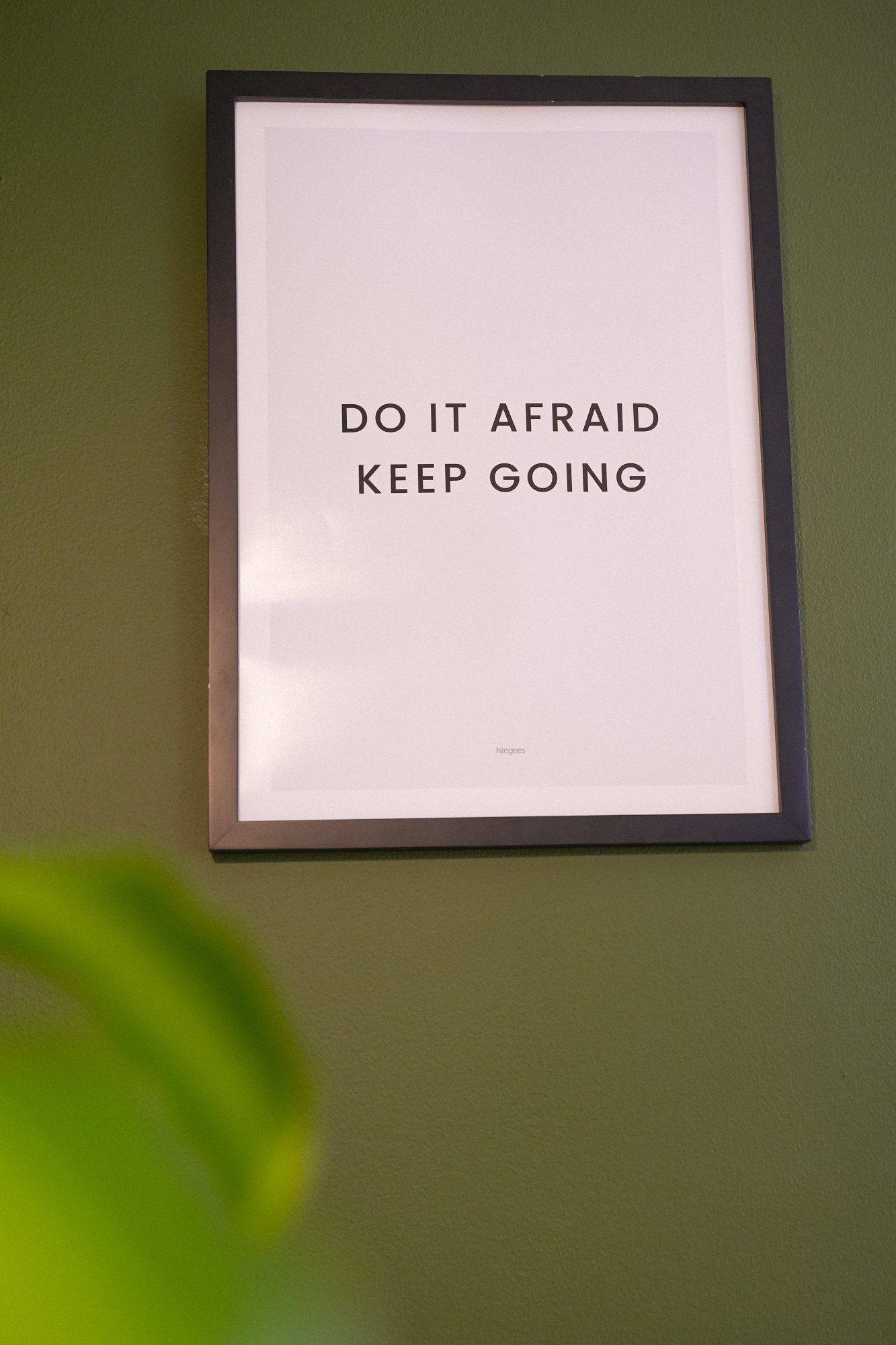 A motivational wall poster with the DO IT AFRAID KEEP GOING quote