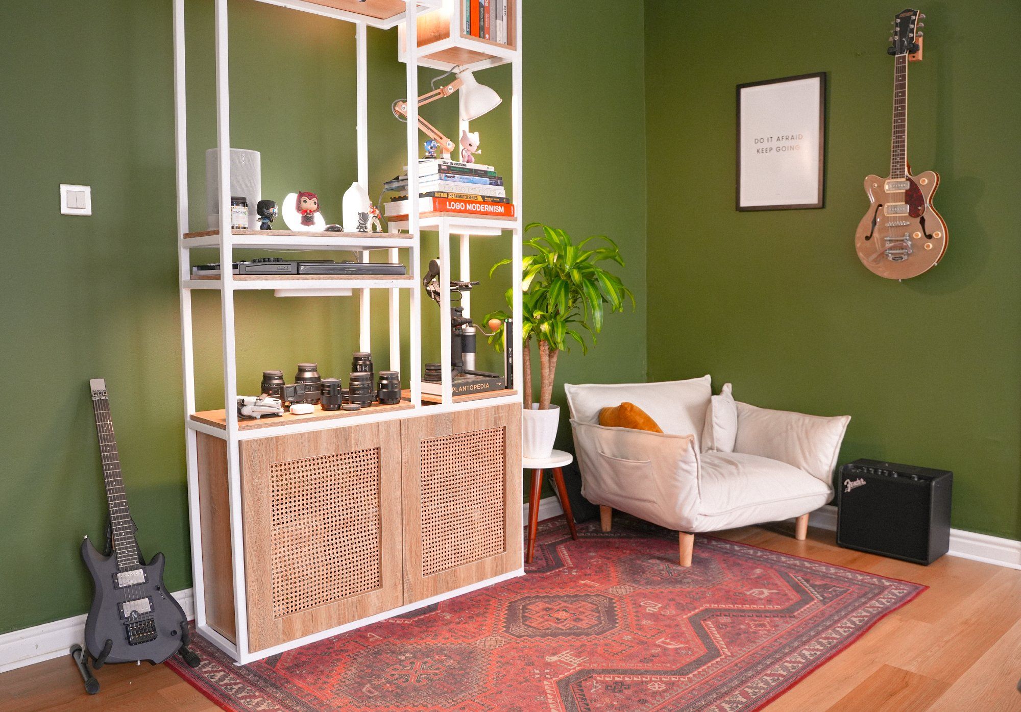 A corner of a home workspace designed for relaxation, featuring palm plants, musical instruments, books, and a comfortable chair