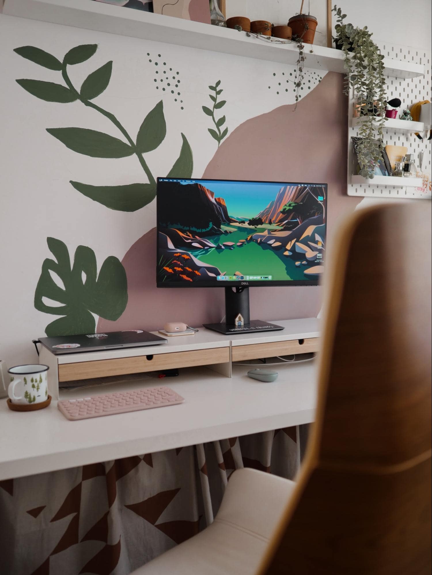 A cosy home workstation featuring a DELL monitor, IKEA ELLOVEN monitor stands, some plants, as well as hand-painted floral ornament on the wall and the Cool Lake desktop wallpaper