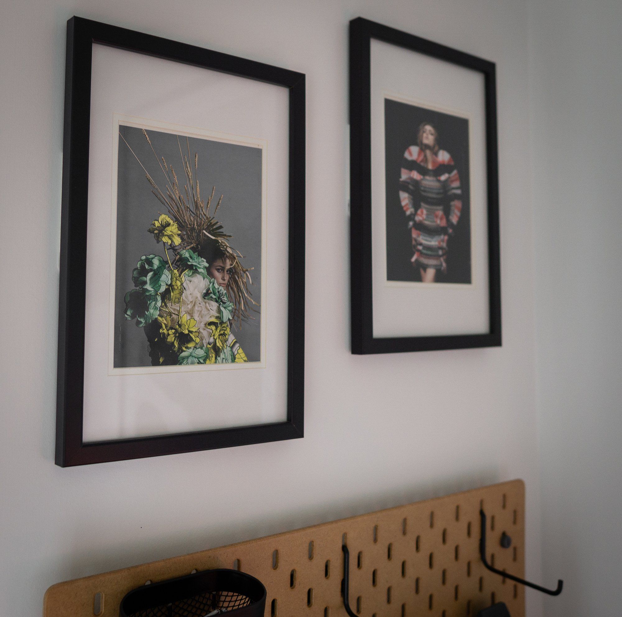 Two wall art posters and a pegboard in a home office in Australia