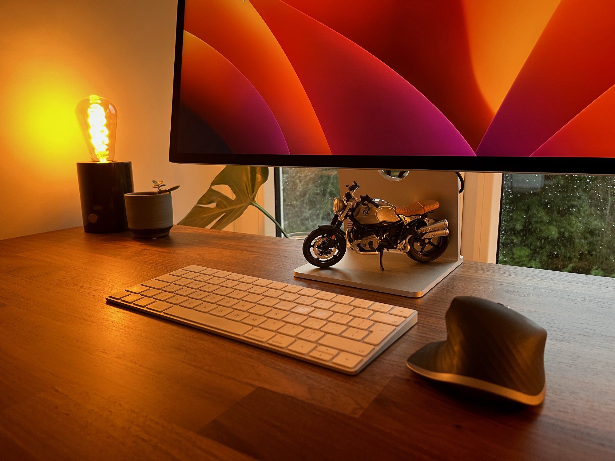 The desk setup featuring a miniature BMW R Nine T Scrambler motocycle model