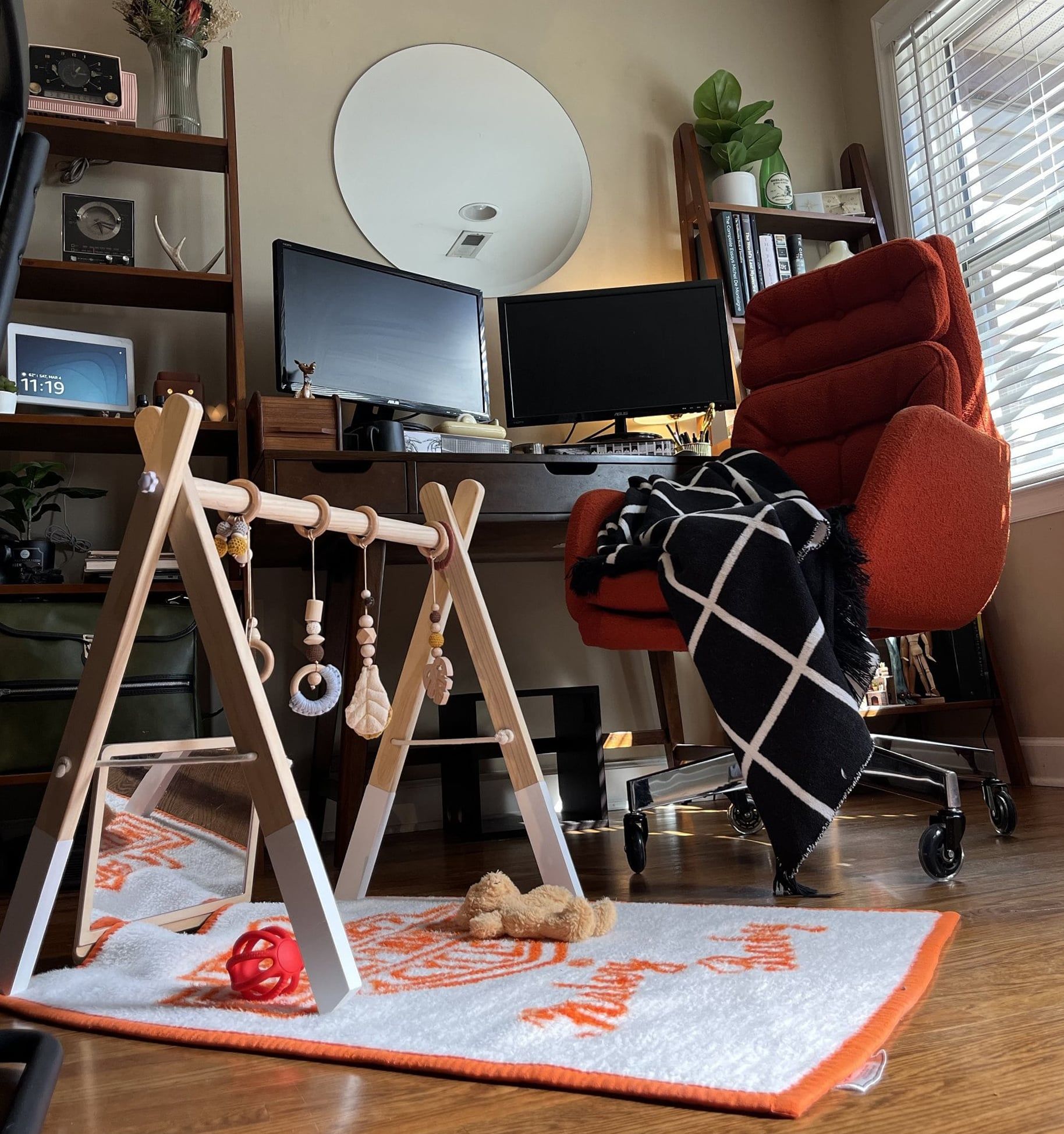 The wooden floor and a dedicated baby playround area with a patterned rug