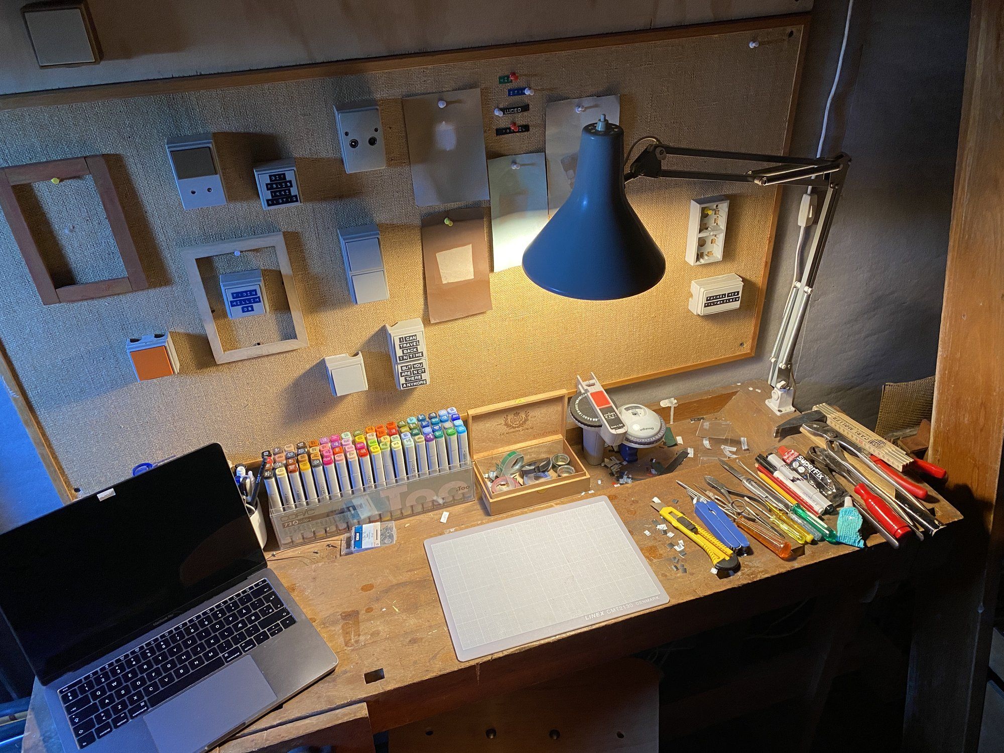 A cosy attic workspace belonging to a street artist, featuring a rustic wooden desk with an assortment of art supplies and tools
