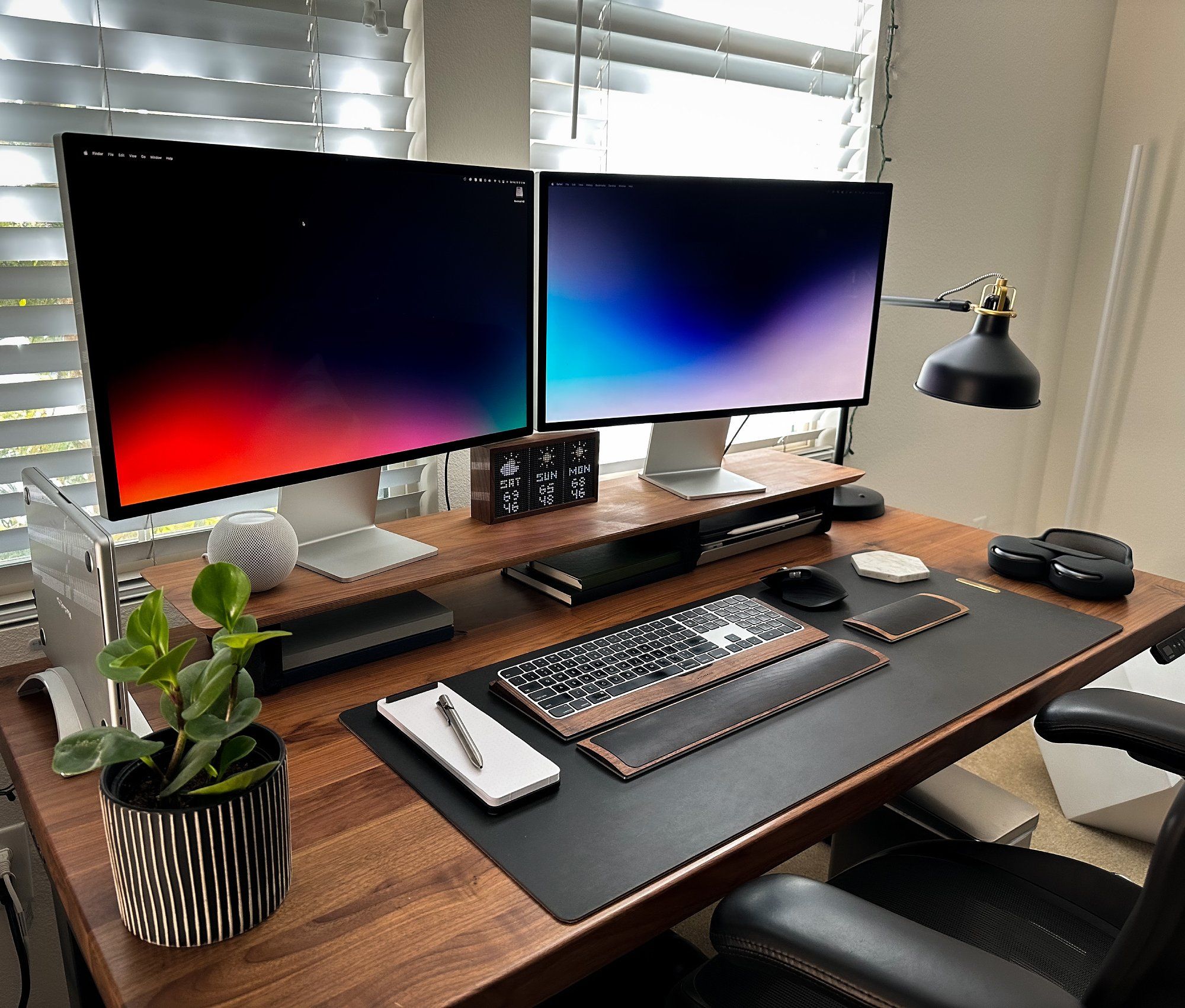 A home desk setup with two Apple Studio Display monitors