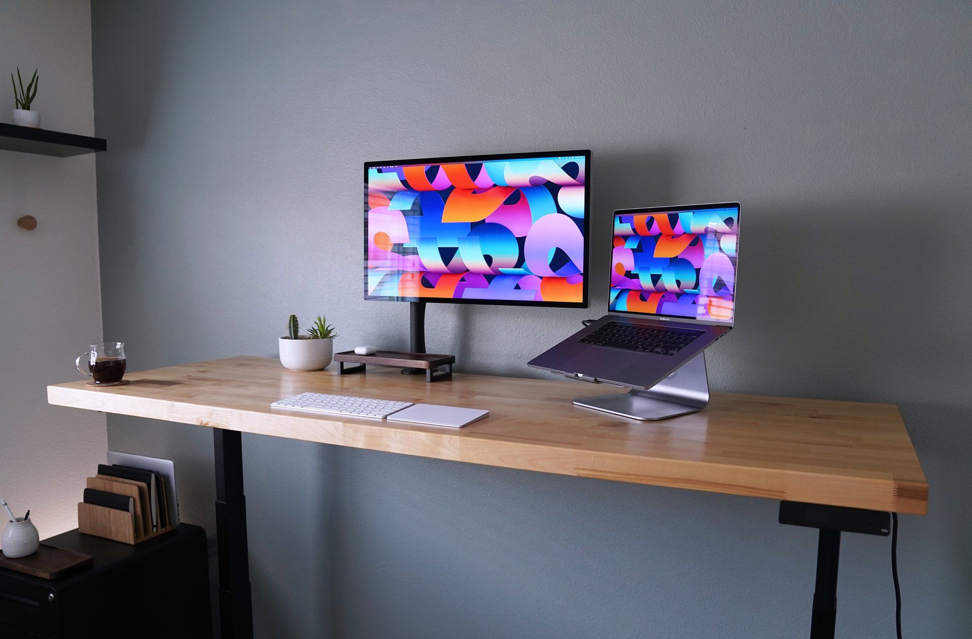 The minimal standing desk setup with a cup of coffee and a succulent planter