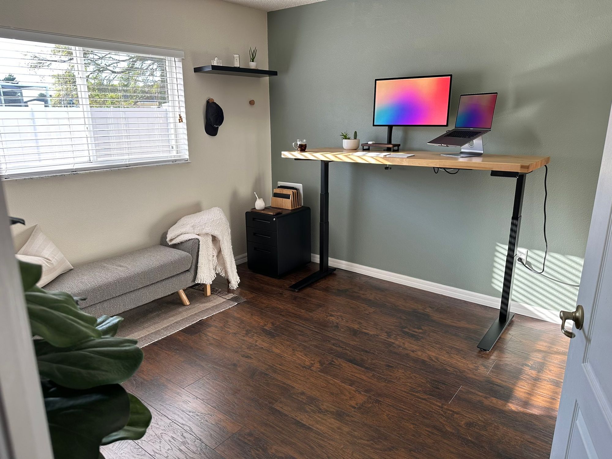 A spacious standing desk setup with a monitor and a laptop