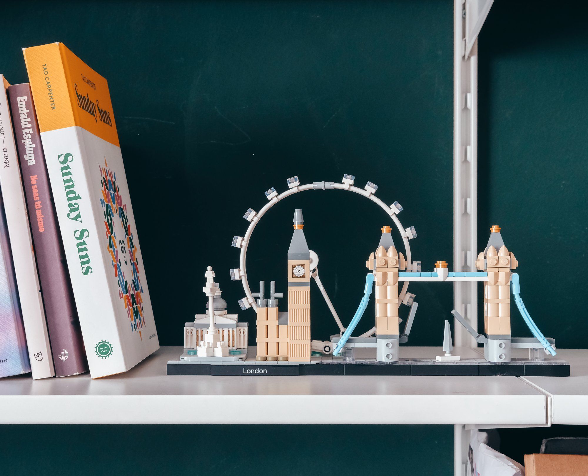 A LEGO Architecture London construction set and some books, including Sunday Suns by Tad Carpenter, on a floating shelf