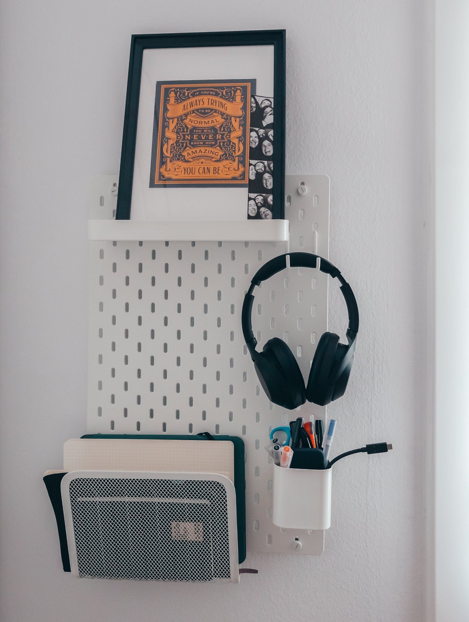 A pegboard with headphones and some stationery