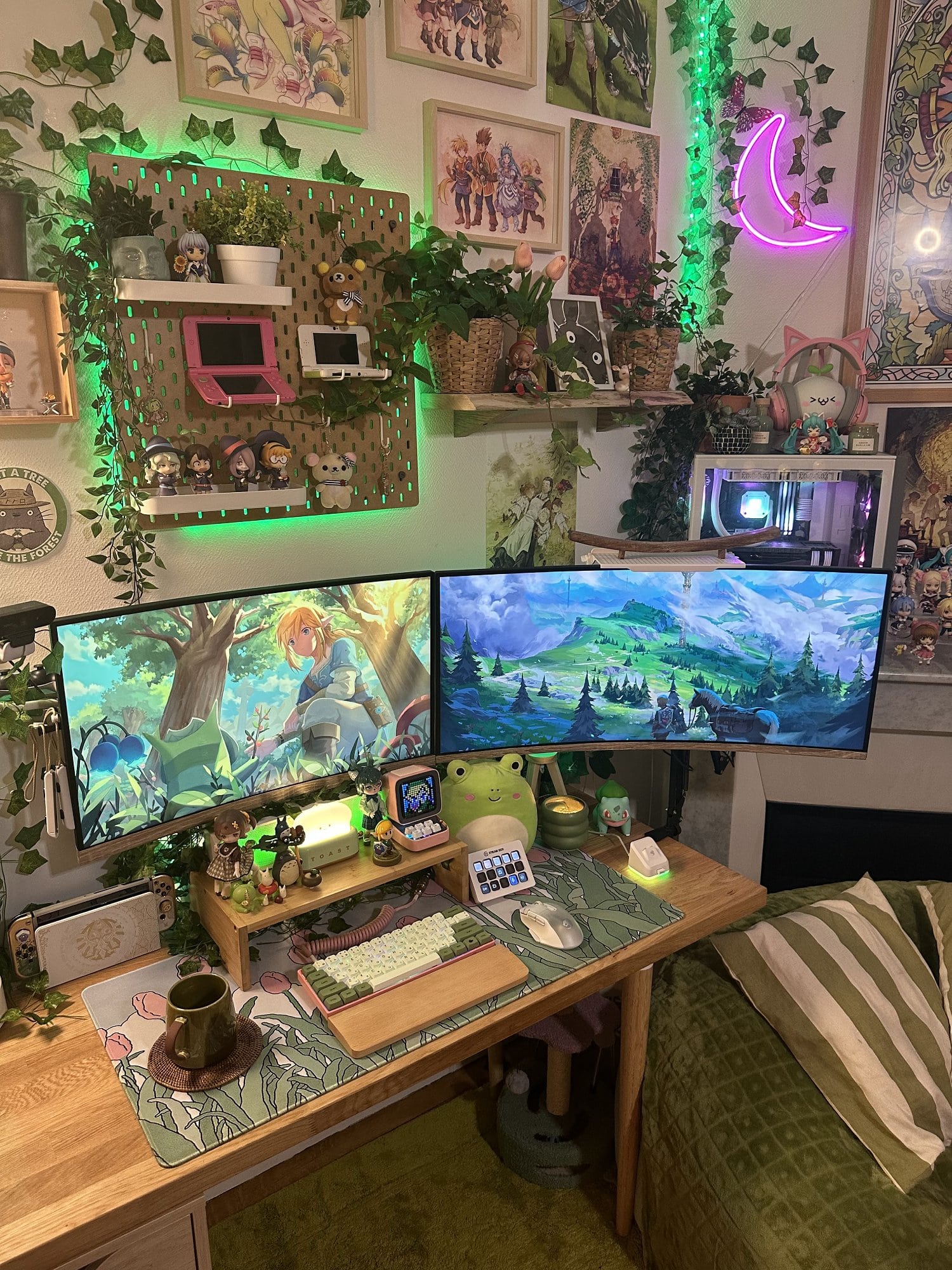 A gaming setup in green with smart LED lighting, artificial plants, Japanese figurines and dolls from anime, manga, and video games, and lots of wall art