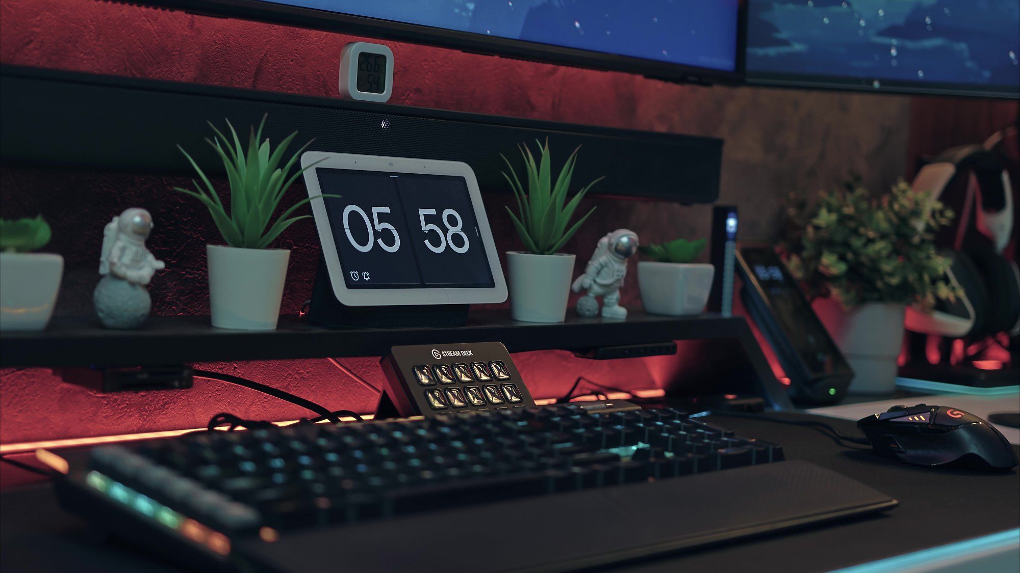 A desktop setup featuring a Corsair K95 Platinum keyboard, a Logitech G502 wired mouse, as well as some figurines and artificial plants
