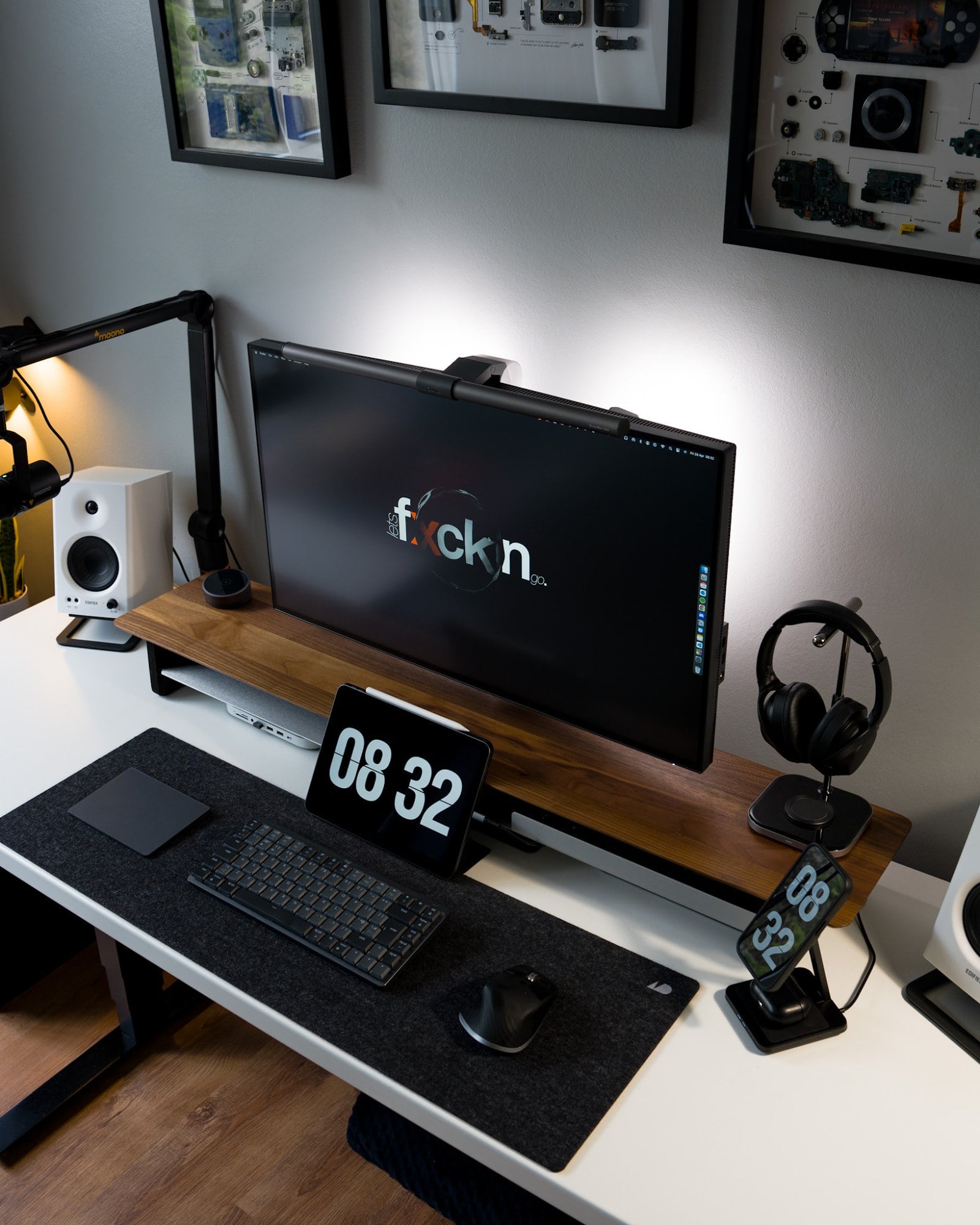A minimal black and white desk setup featuring a BenQ PD3220U monitor, Edifier MR4 speakers, and Sony XM3 headphones, among other devices and peripherals