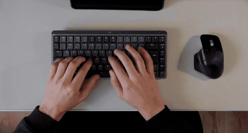 An animated GIF of a man’s hands typing on a Logitech MX mechanical mini keyboard; next to it is a Logitech MX Master 3 for Mac mouse