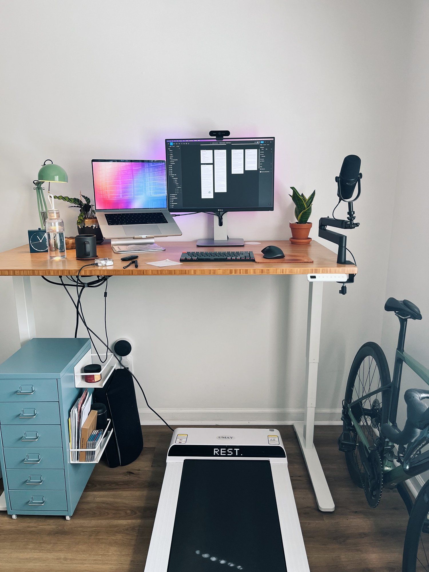An UMAY treadmill placed under the desk in a designer’s home office