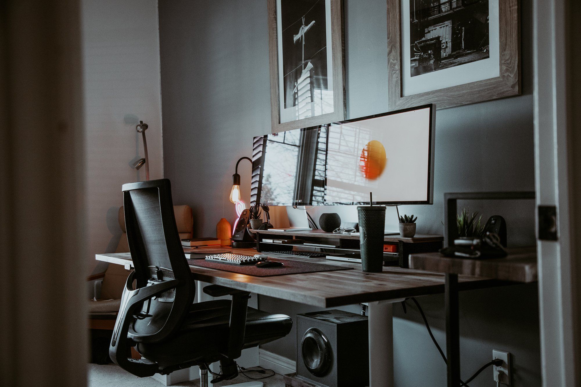 A creative workspace with a custom standing desk and two Apple Studio Displays