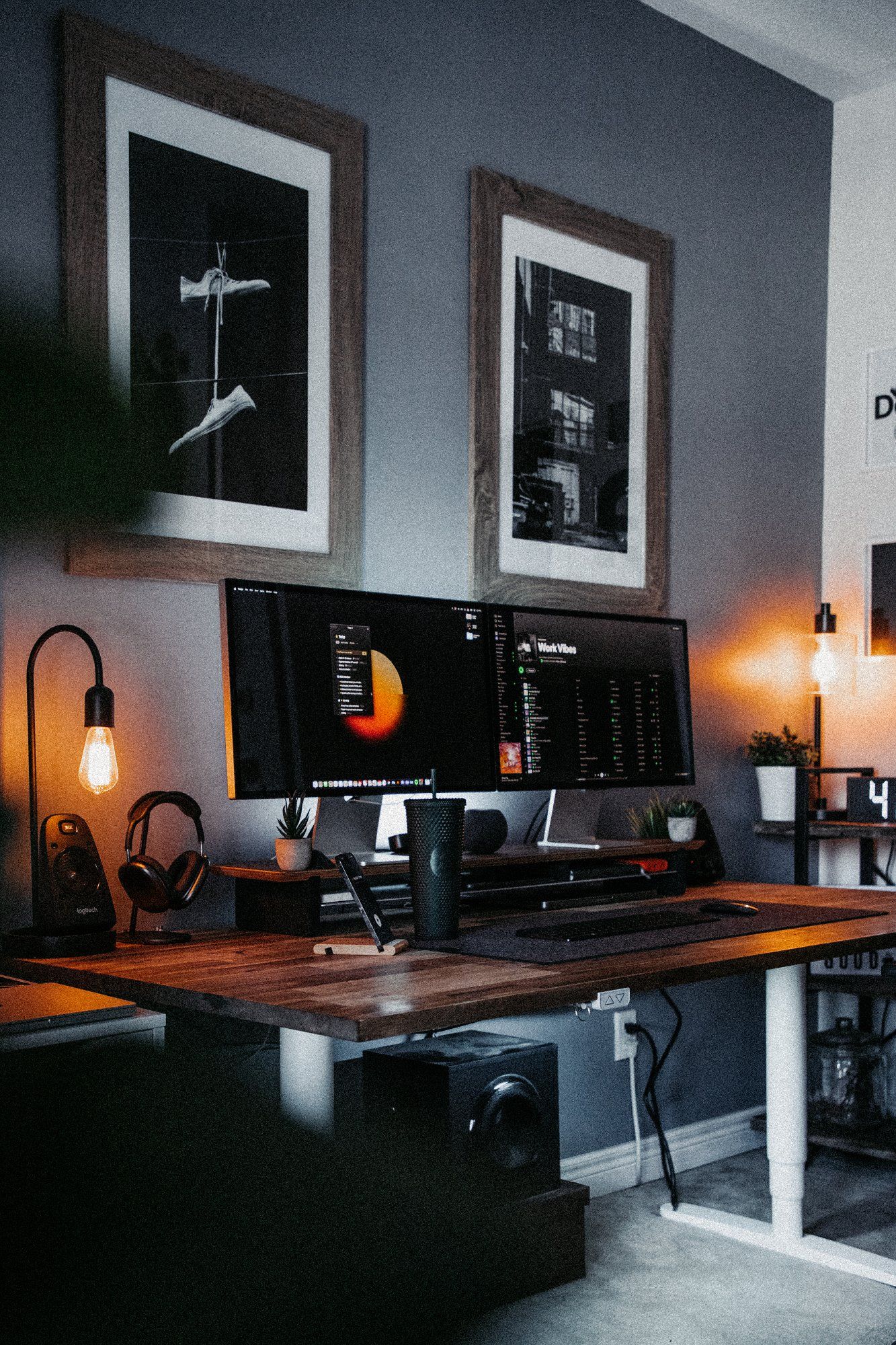 A view from the left of a neat designer standing desk setup with two Apple Studio Displays