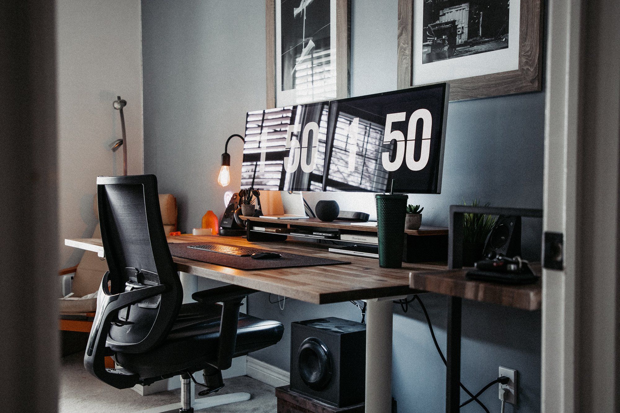 A view from the right of a well-built desk setup with two Apple Studio Displays sitting on the Grovemade desk shelf