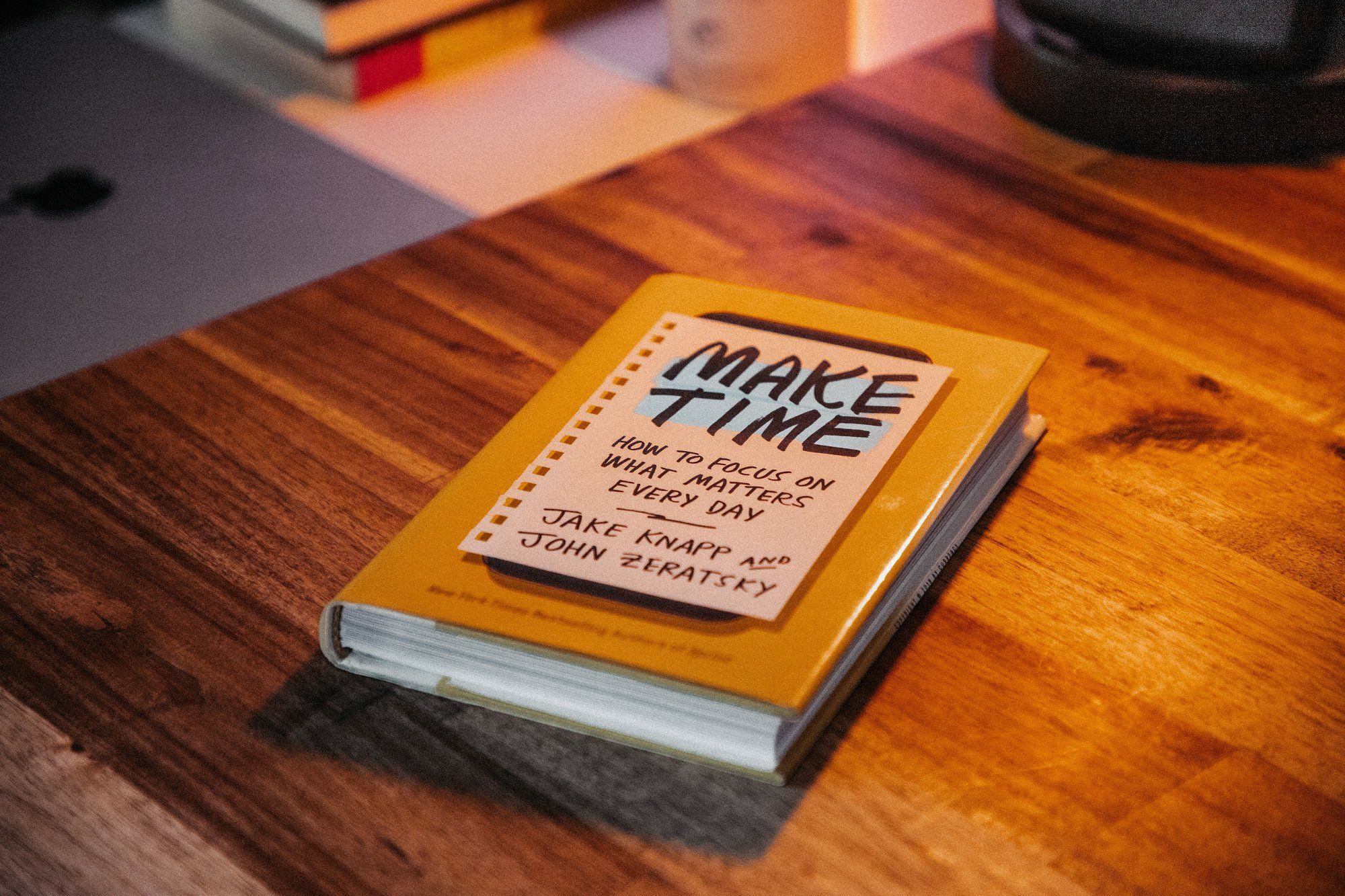 A Make Time book by Jake Knapp and John Zeratsky lying on a desk