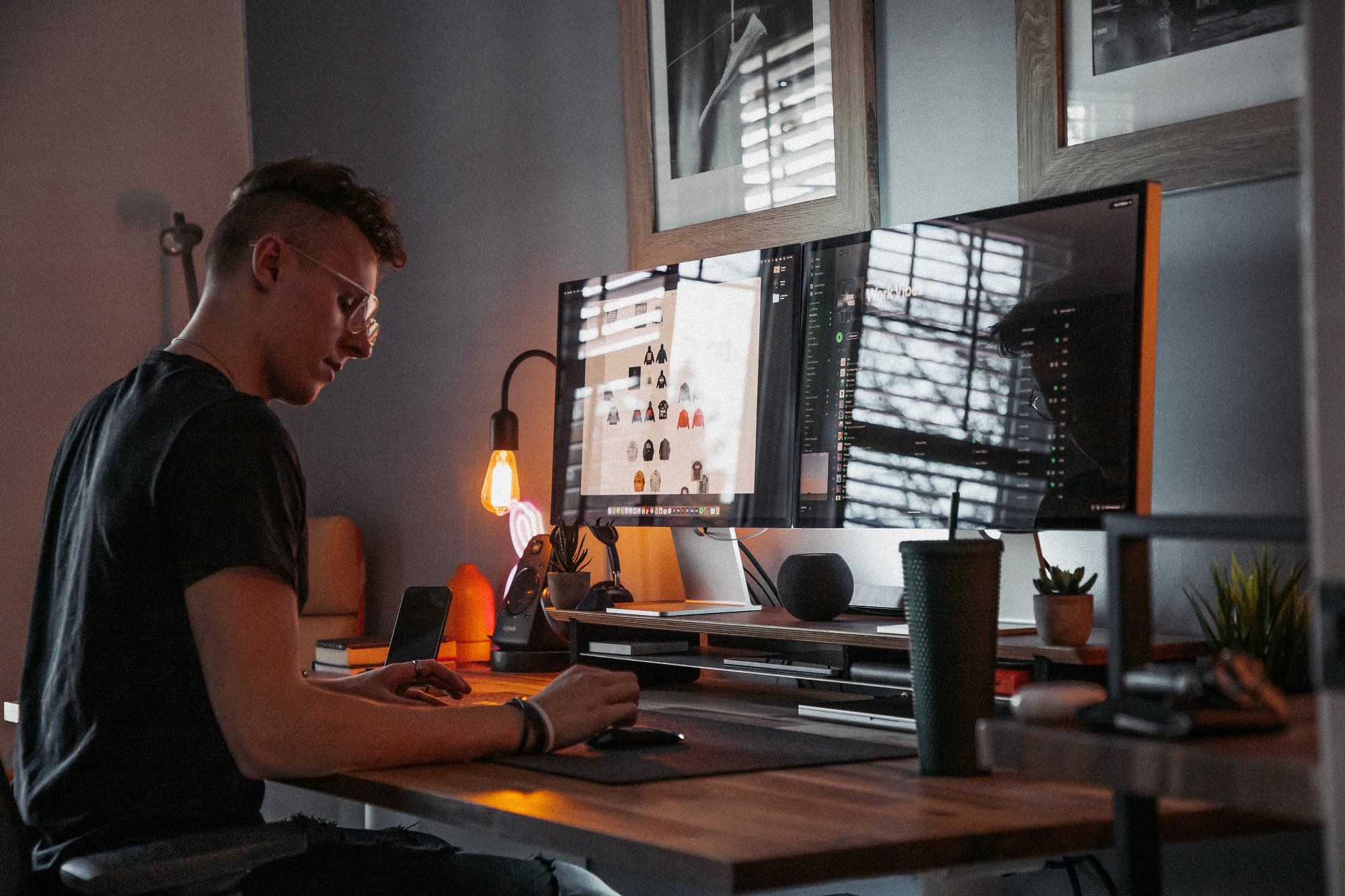 A Canadian designer sitting at his dual Apple Display desk setup