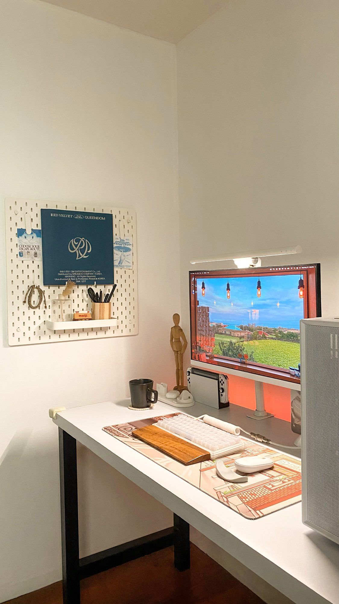 A side view of a minimalist desk setup with a pegboard on the wall