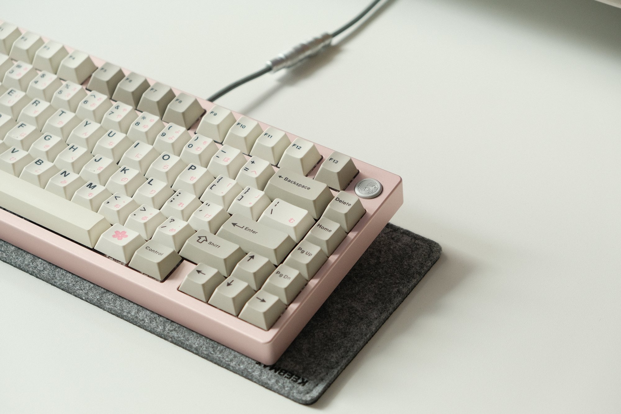 A custom mechanical MONOKEI x TGR keyboard sitting on a Keebmat desk mat
