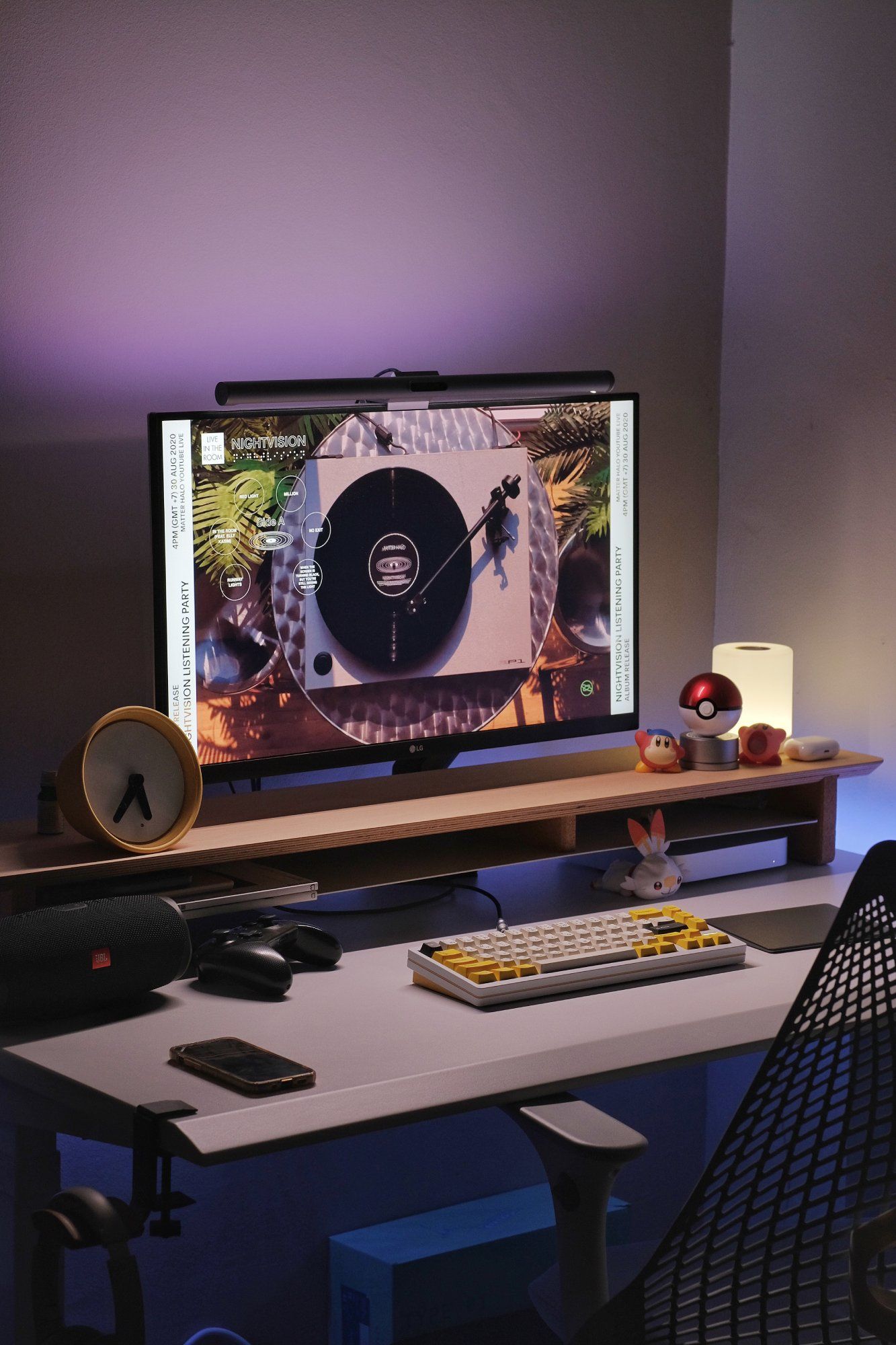 A clean and minimal home office with a custom mechanical keyboard at night