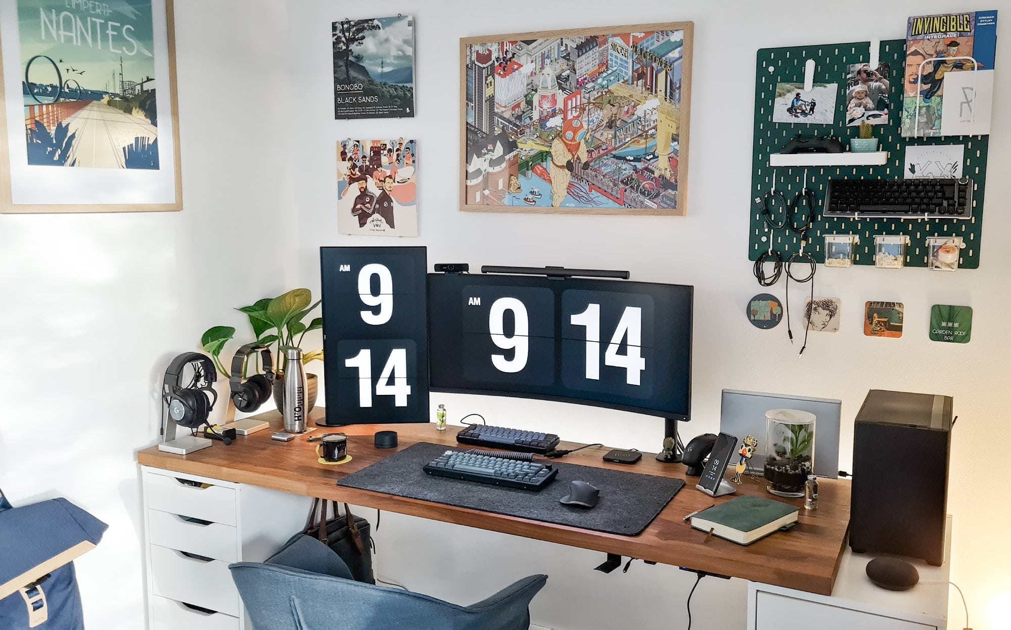 A well-organised personal home office with two monitors and a hand-painted green pegboard