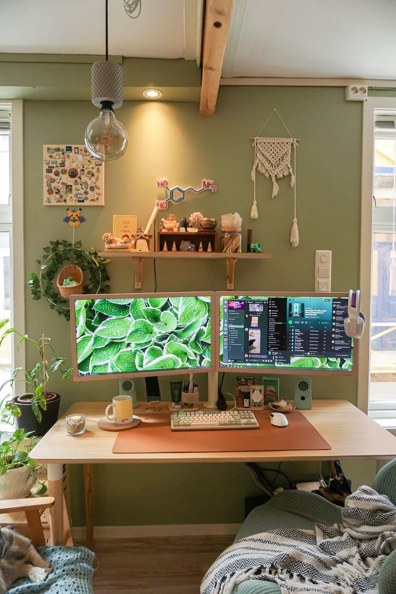 A desk setup featuring two monitors with beige hand-painted frames against an olive green wall painted with Olivenlund by Butinox