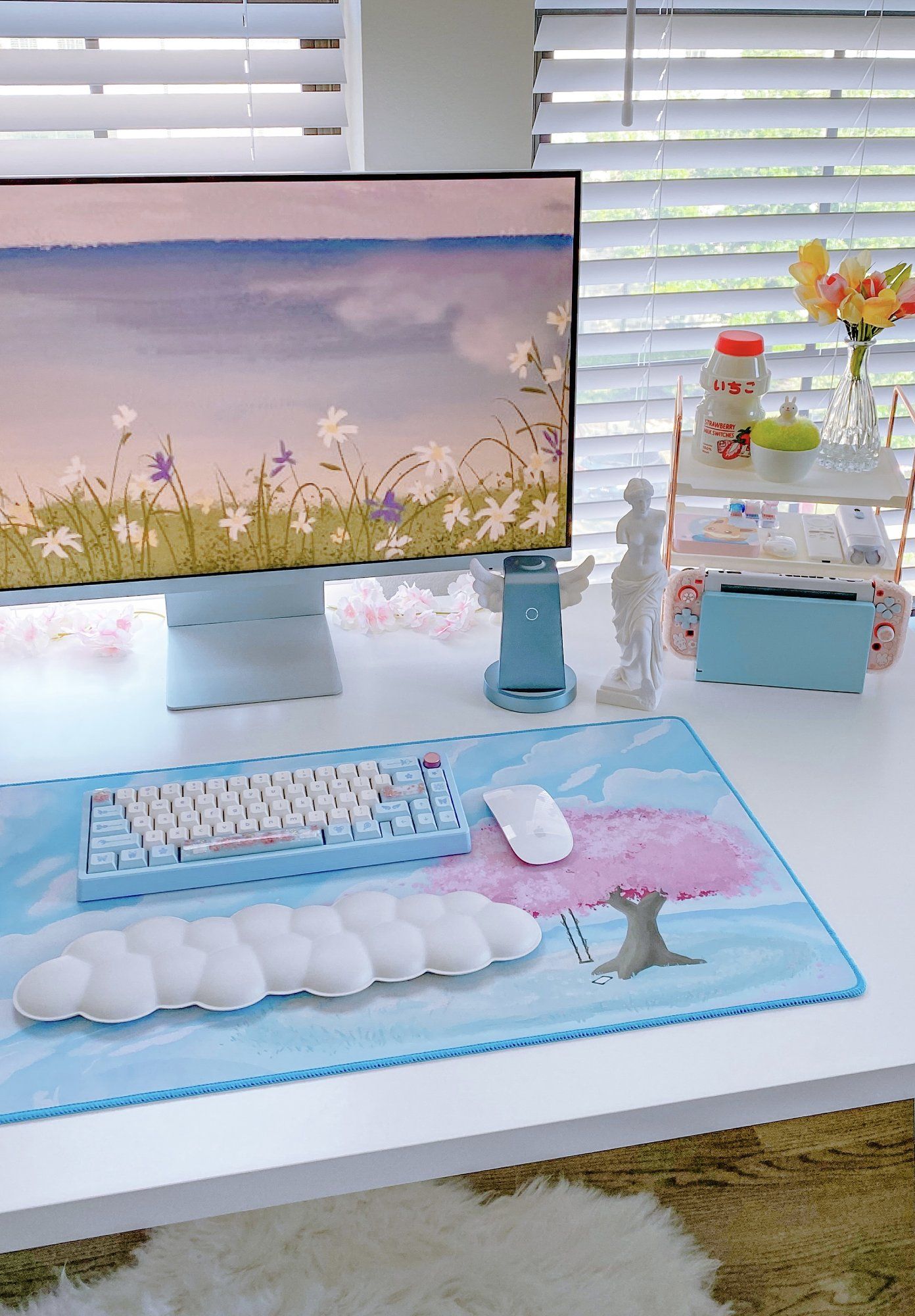 A cute desk setup featuring a Zoom 65 EE mechanical keyboard, an Apple Magic Mouse, and an Aurora Palm Rest on the ePBT Rin Sakura sky Virtual Landscape deskmat