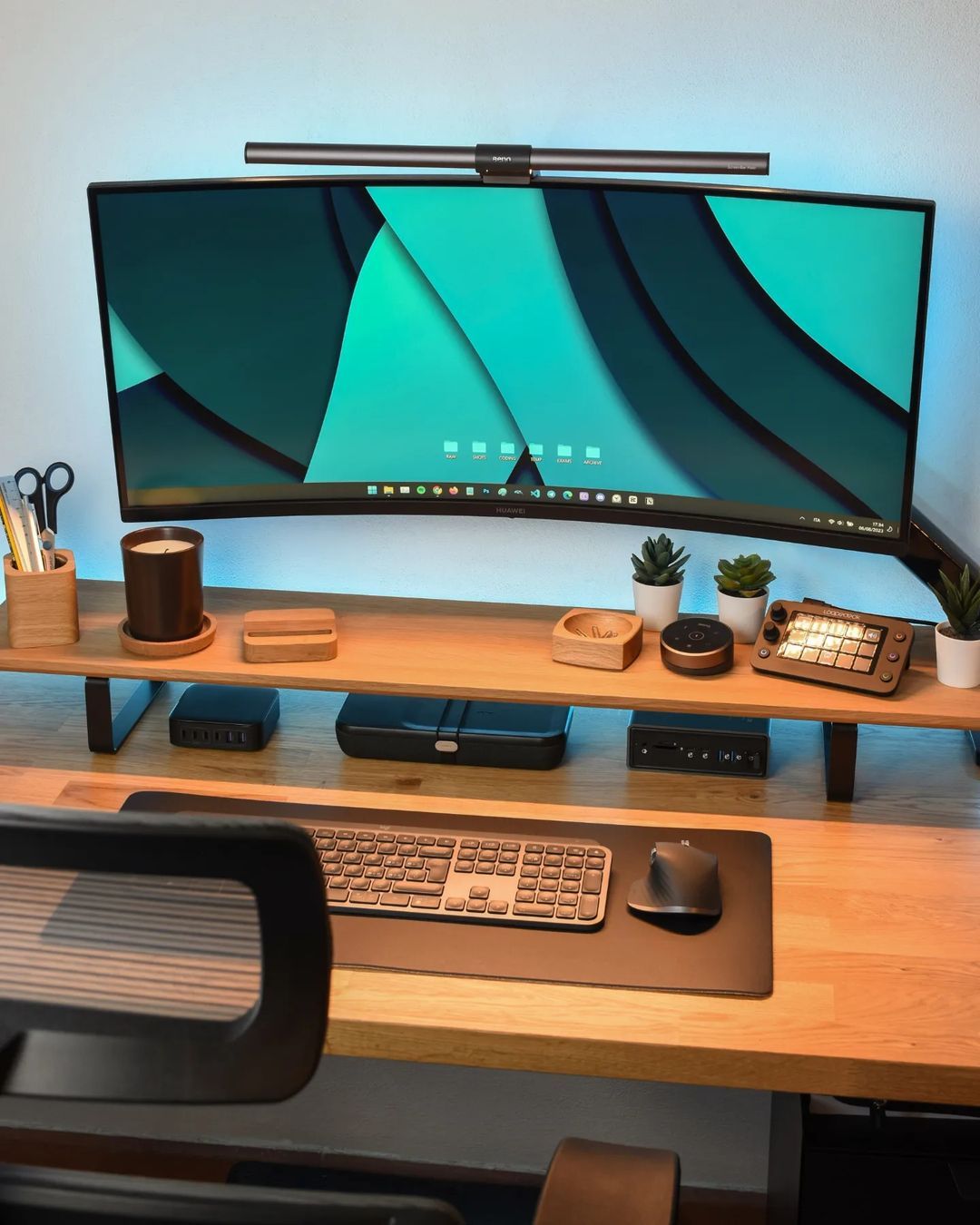 A wooden home office desk setup with a curved HUAWEI MateView monitor