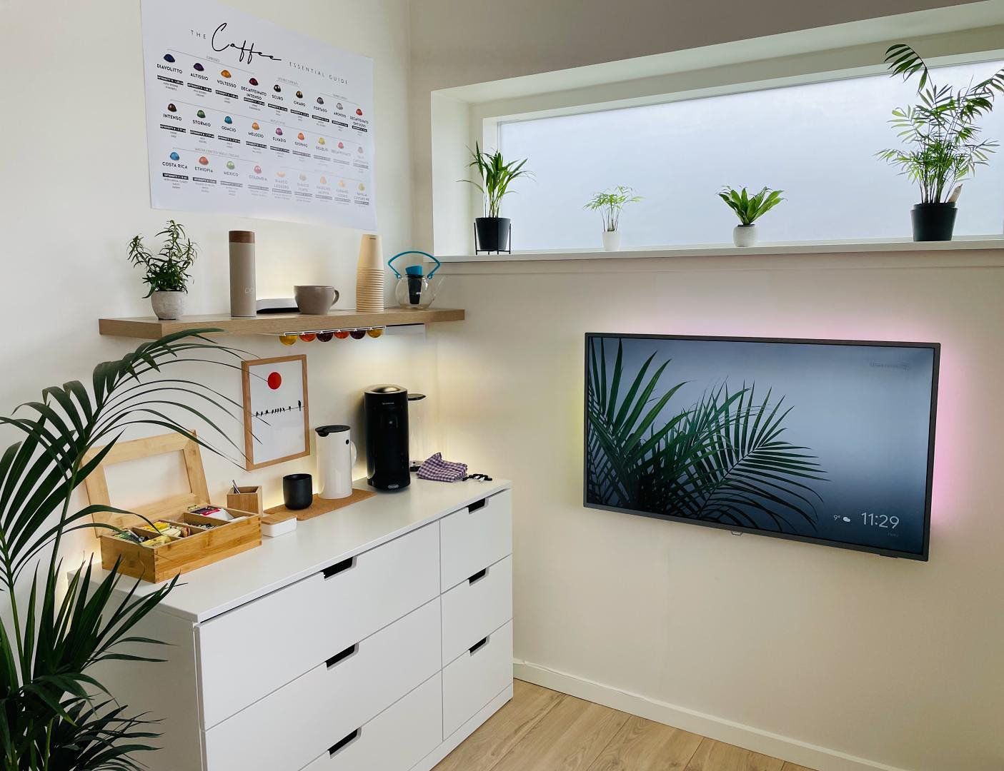 A home office corner with a coffee station and lots of houseplants