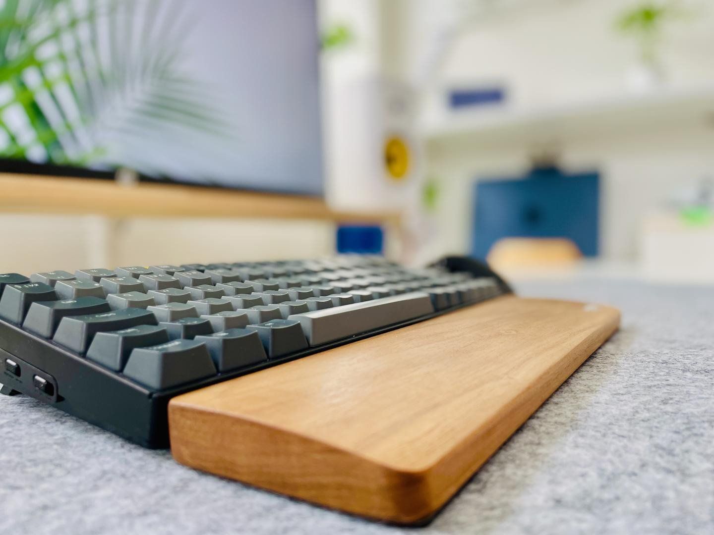 A Keychron K2 mechanical keyboard with a wooden wrist rest