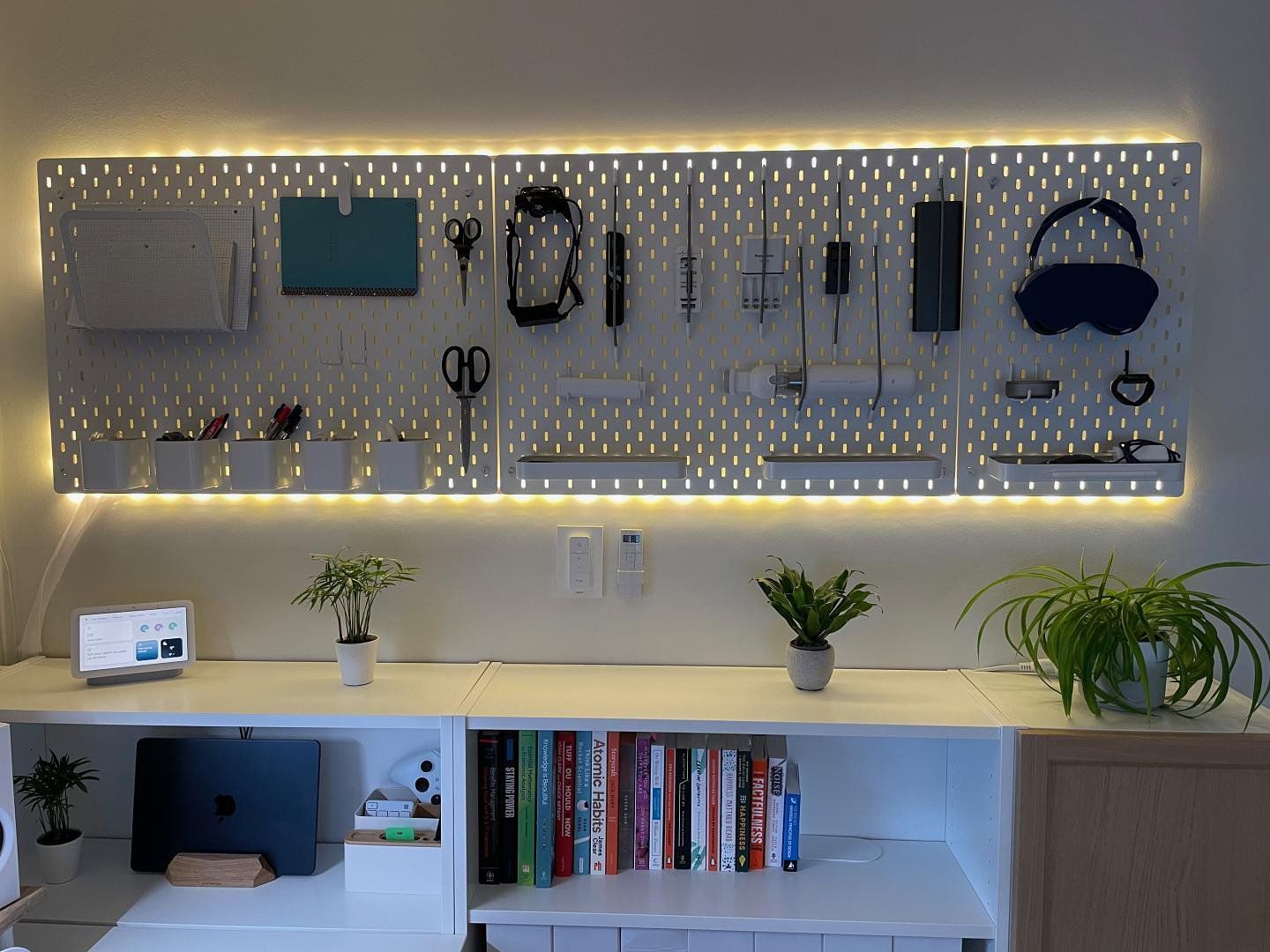 A corner of a minimalistic home office with three pegboards hanging on the wall next to each other