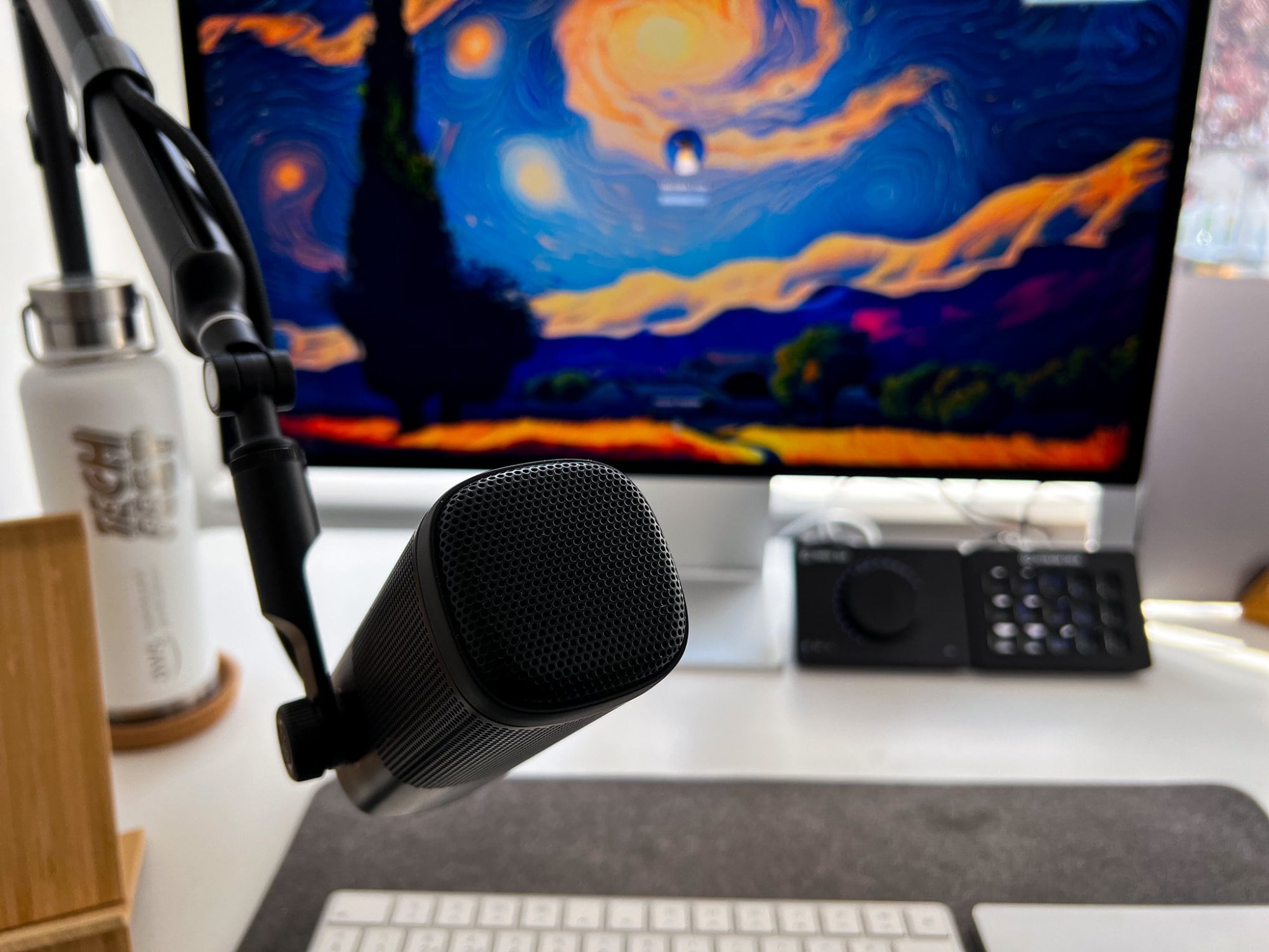A home office desk setup featuring an Elgato Wave DX XLR microphone