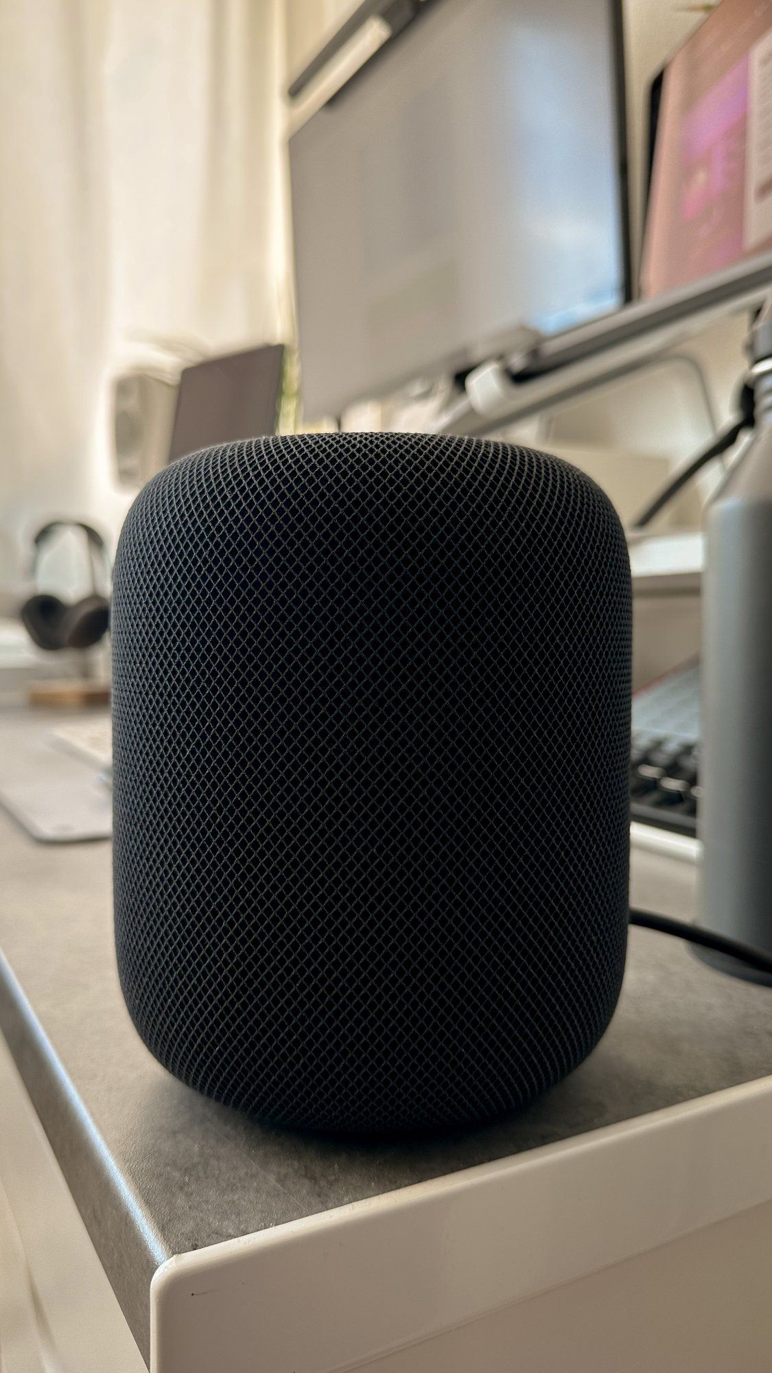 An Apple HomePod Bluetooth speaker in space grey