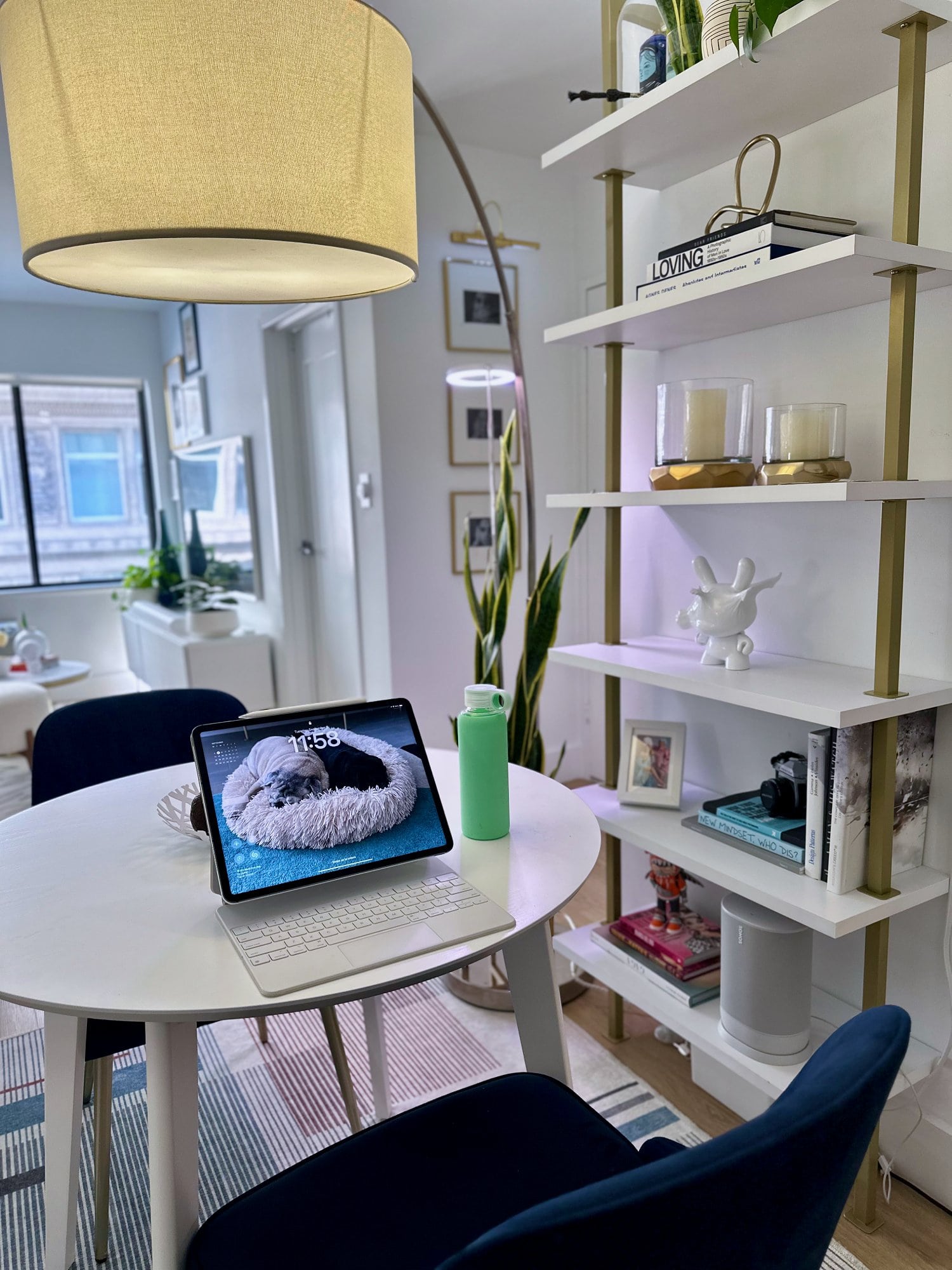 A small dining table with an iPad, a keyboard, and a water bottle on it