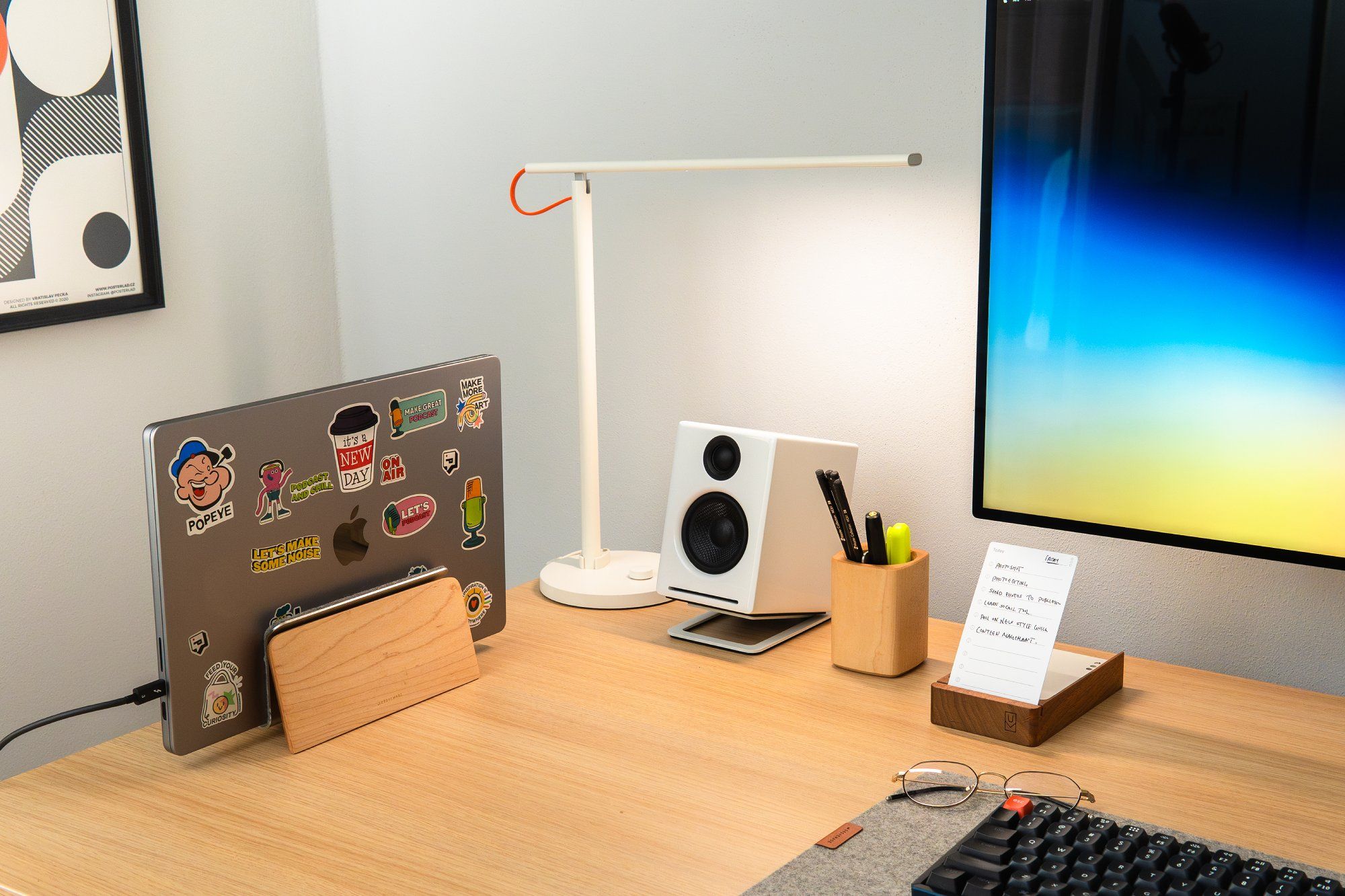 Góc bên trái của bàn làm việc trưng bày một chiếc MacBook M1 trên giá đỡ, kèm theo đèn bàn LED Xiaomi