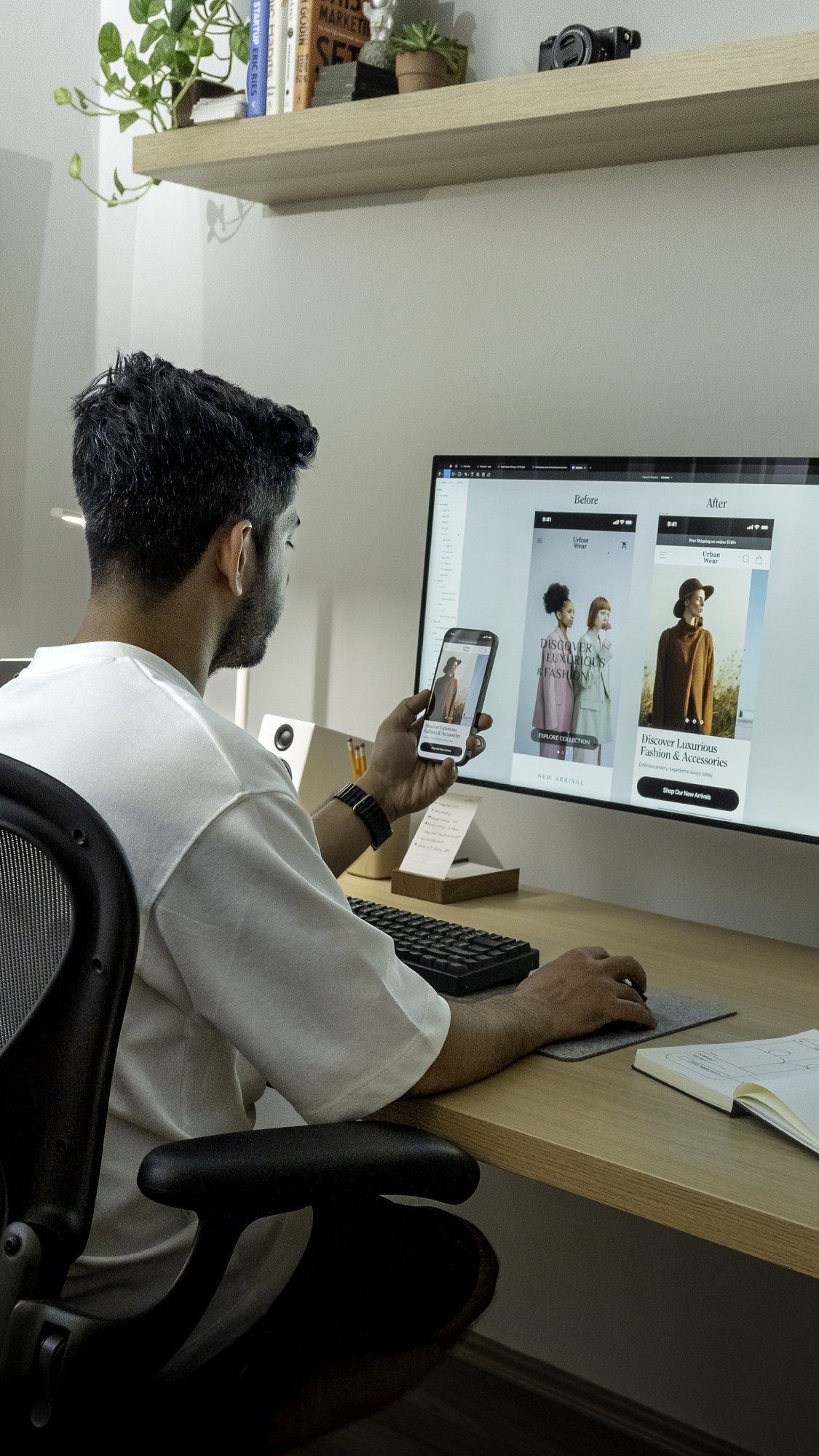 A working-from-home designer sitting at their desk and looking at their smartphone