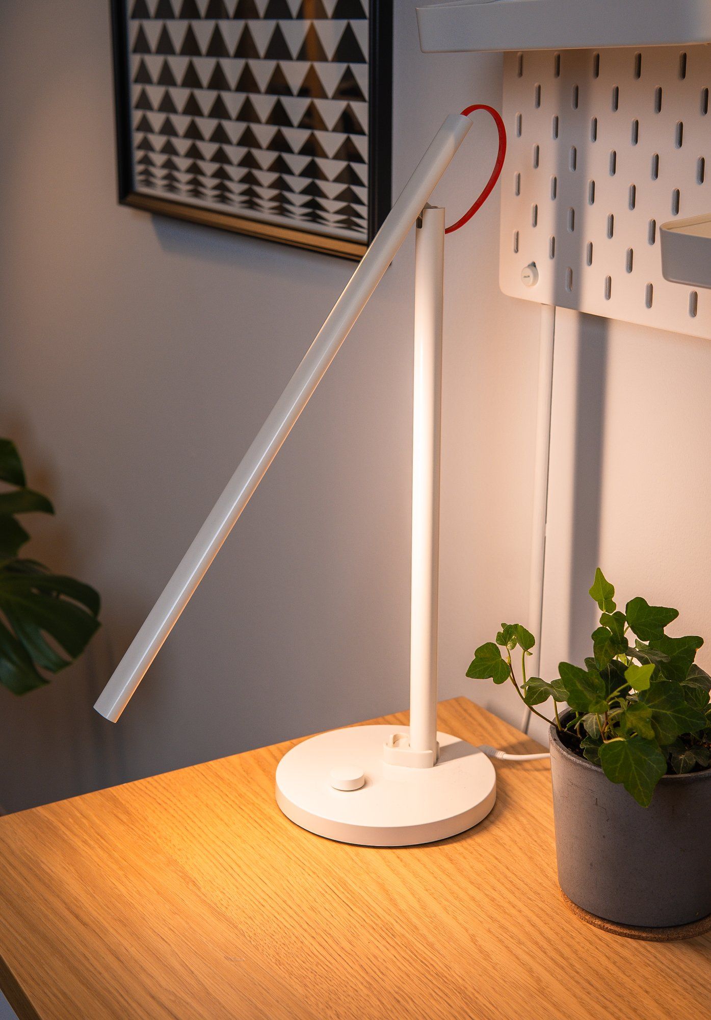 A Xiaomi white desk lamp and a potted plant on a desk