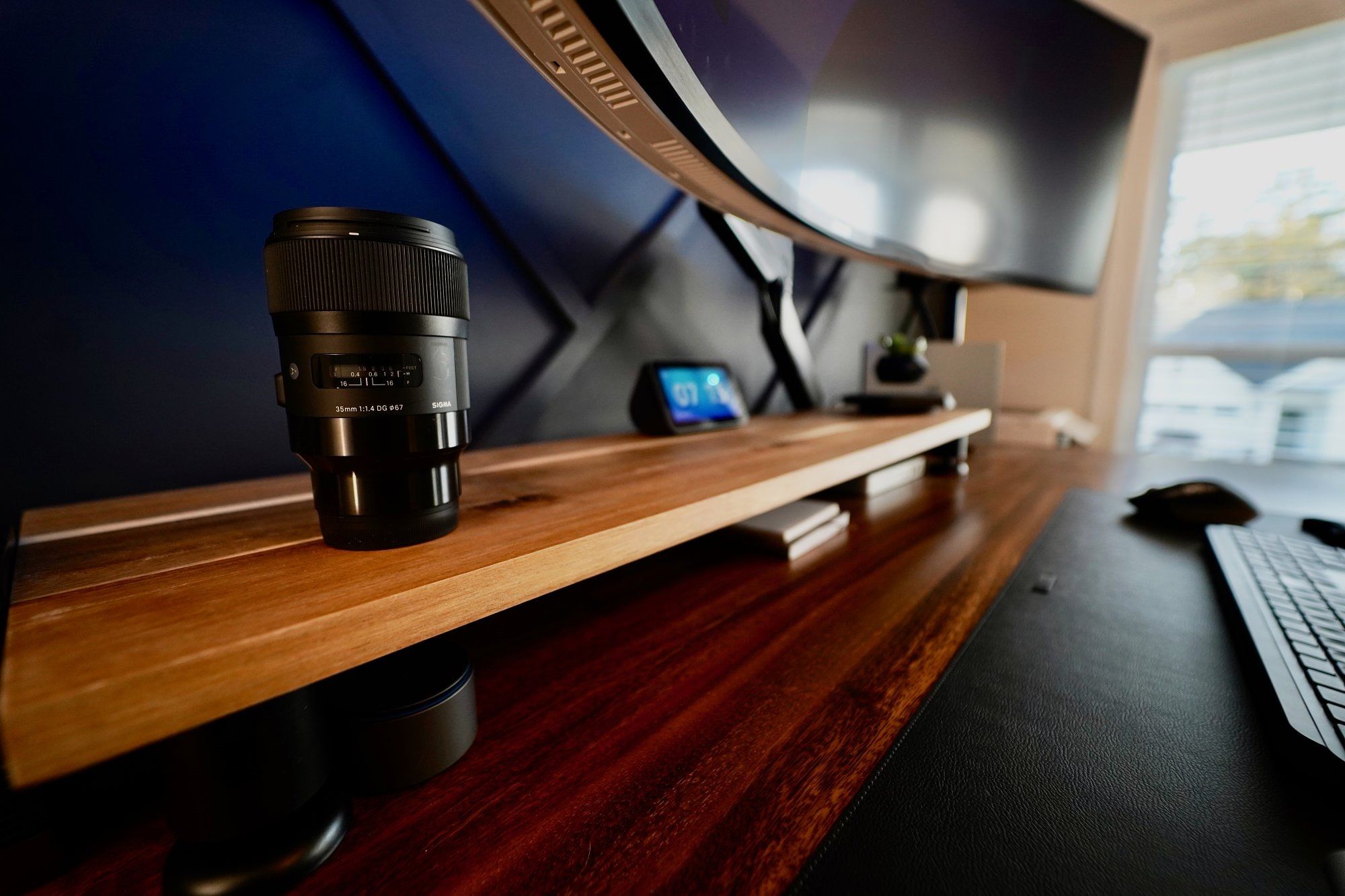 A Sigma DG HSM lens on a desk shelf