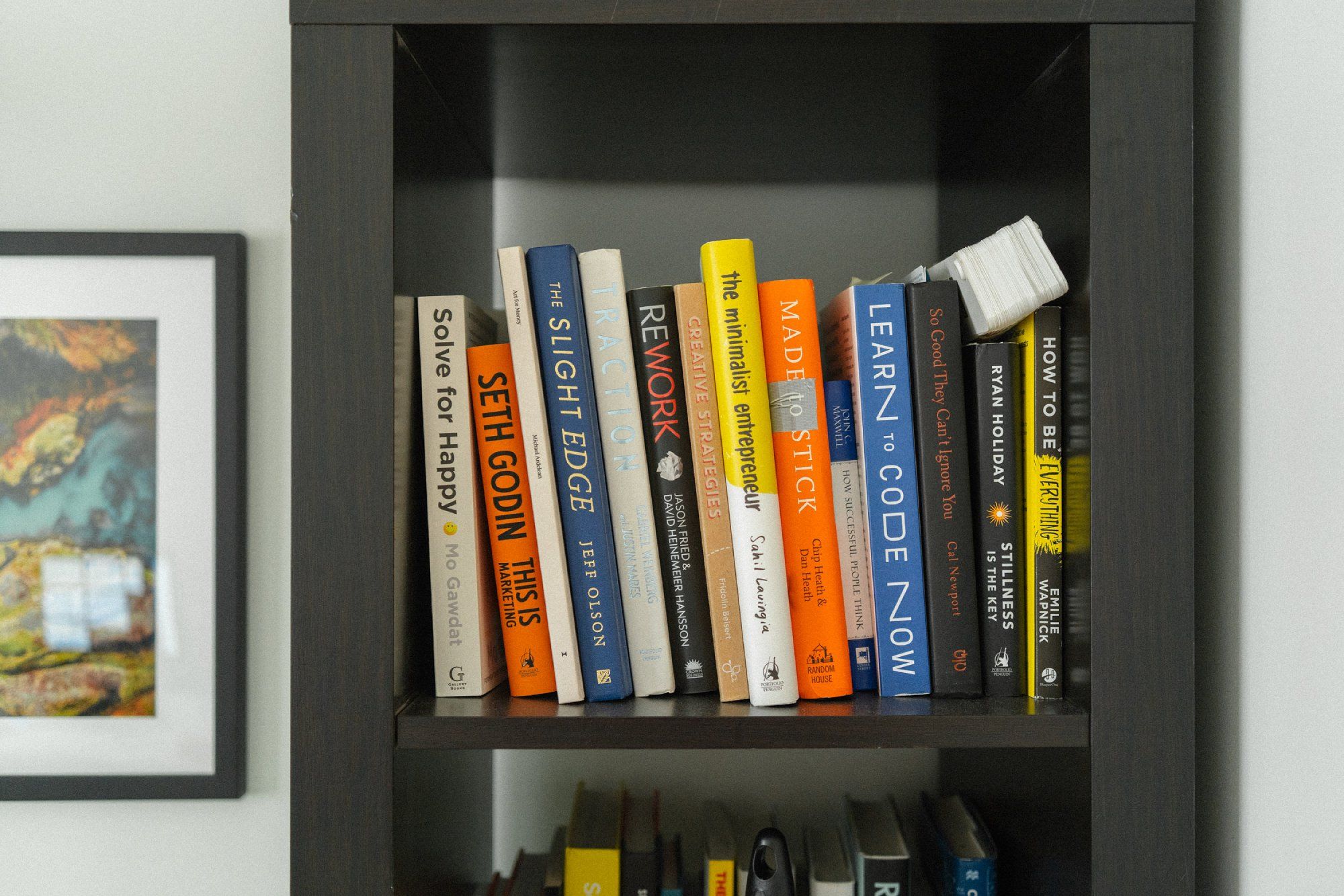 A bookshelf with books on marketing, coding, and design
